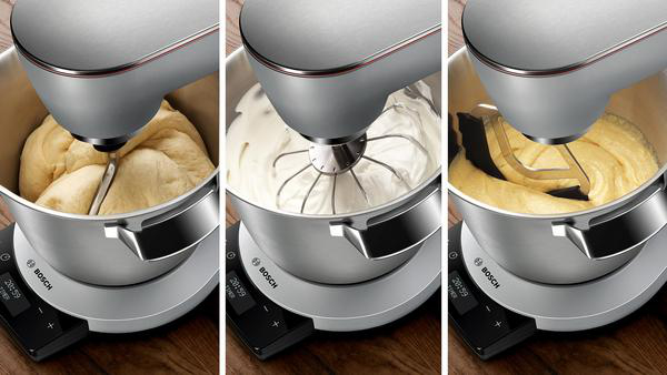 Ein Mixer mit Teig, Schlagsahne und Teig in der Schüssel.