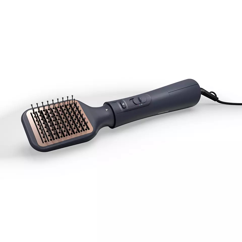 Eine dunkelgraue Haarstyling-Bürste auf weißer Oberfläche, mit schwarzem Netzkabel.