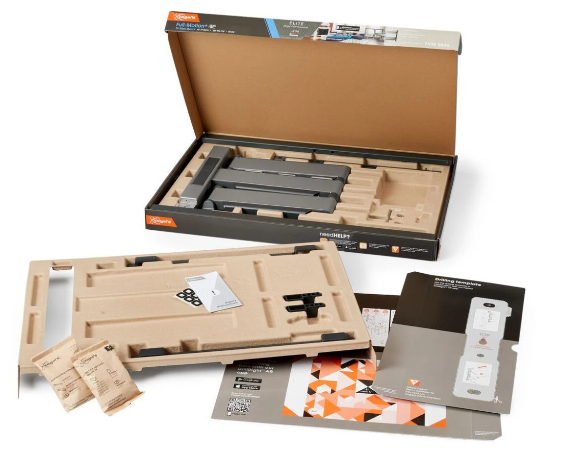 Geöffnete Box mit TV-Halterungsteilen. Graue Halterung, Kartonverpackung, Bedienungsanleitungen und kleine Beutel mit Schrauben etc. sichtbar.