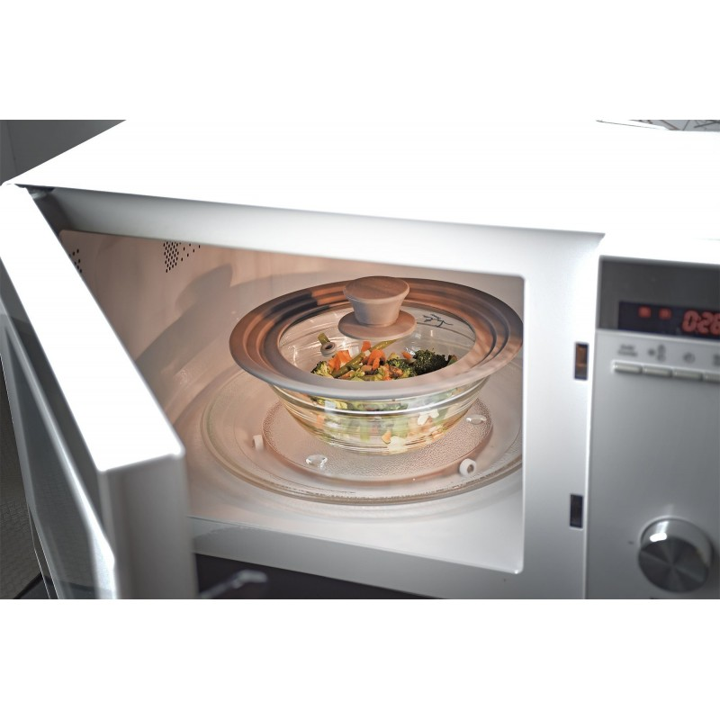 Un horno de microondas con un cuenco de verduras dentro, cubierto con una tapa.