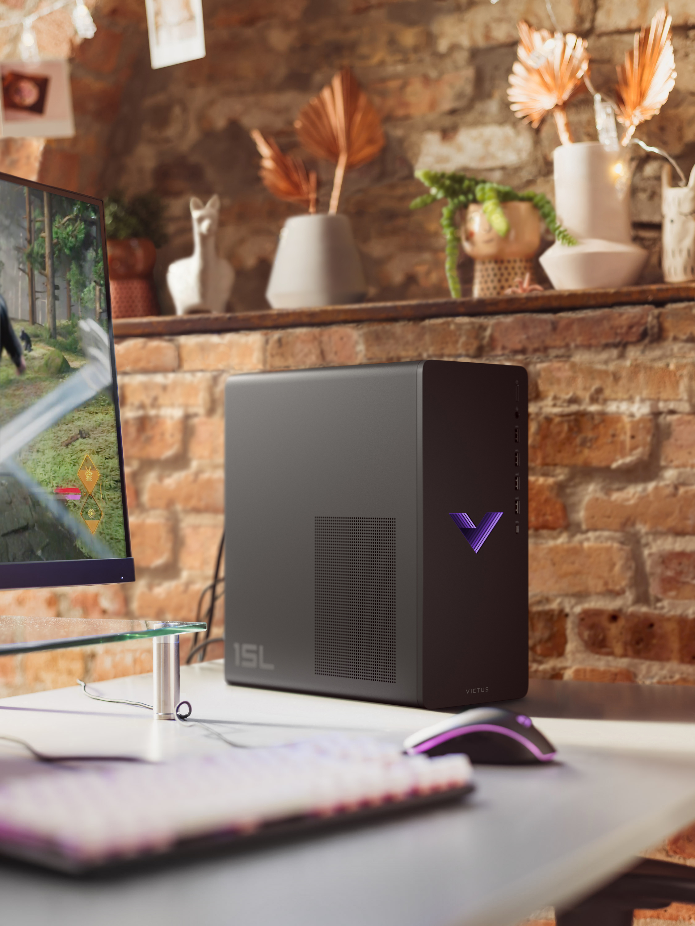 Schwarzer Desktop-Computer mit lila Logo auf einem Schreibtisch mit Monitor und anderen Gegenständen.