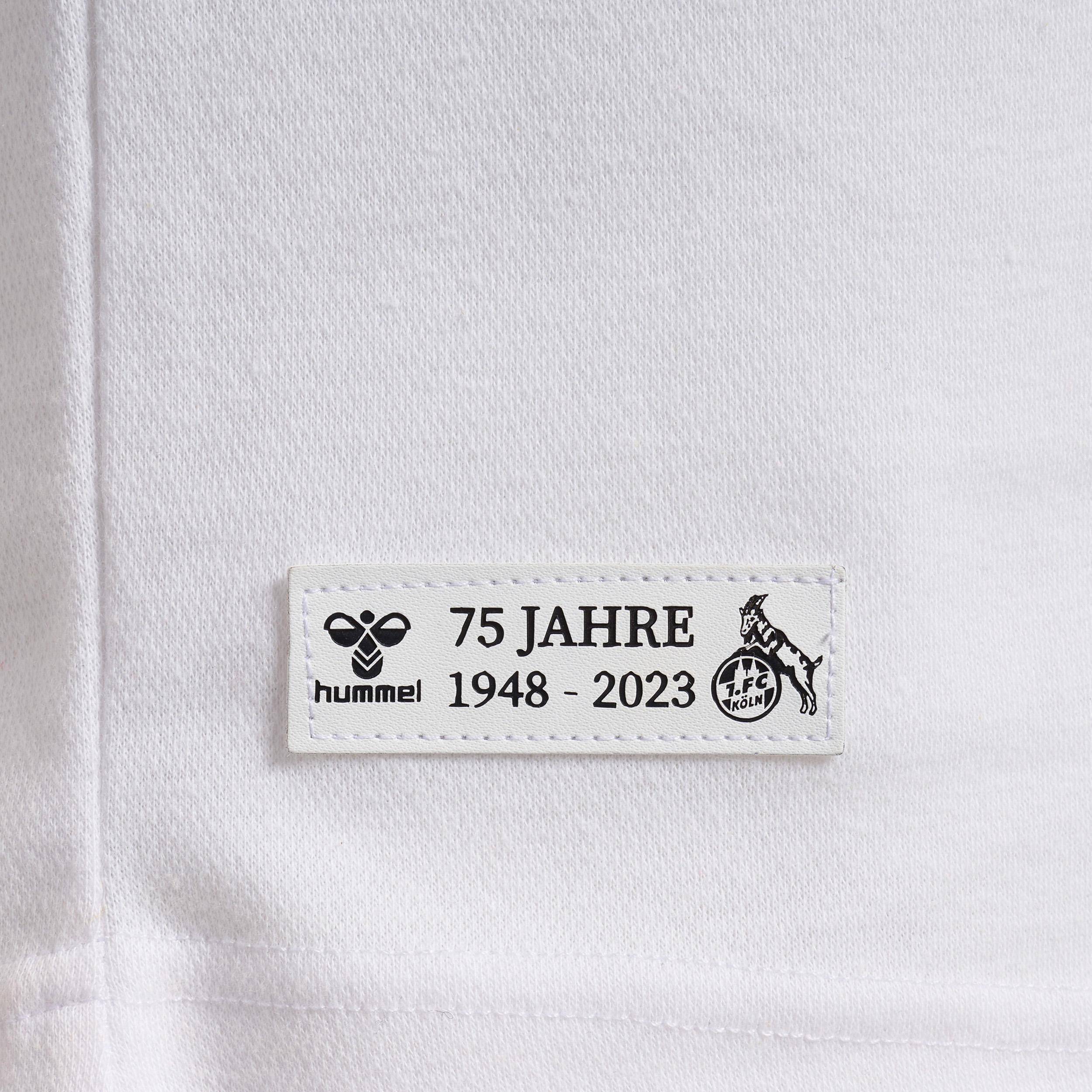Nahaufnahme eines weißen Trikots mit einem Aufnäher von 75 Jahren, Hummel-Logo und FC Köln-Logo.