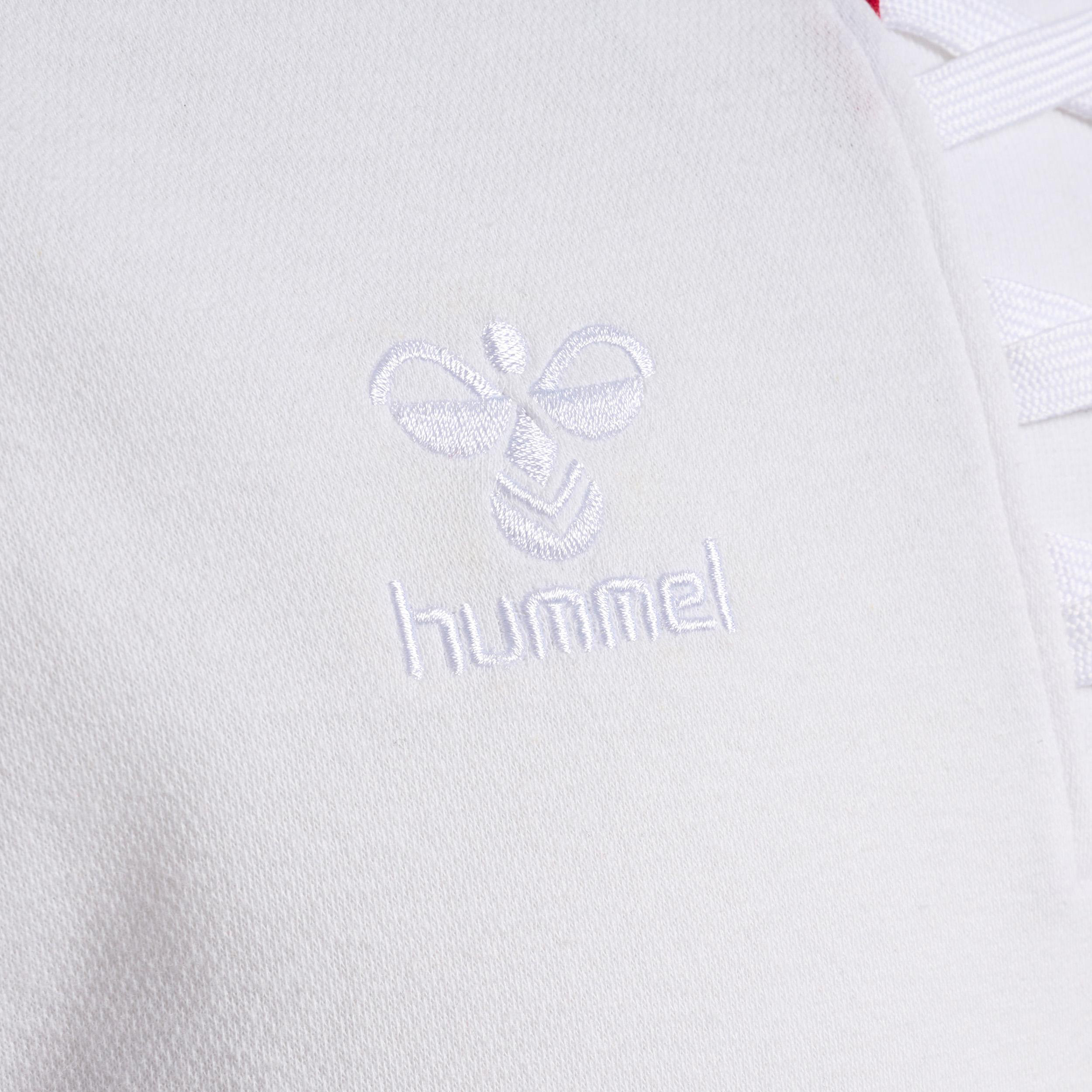 Nahaufnahme eines weißen Stoffes mit dem gestickten Hummel-Logo.