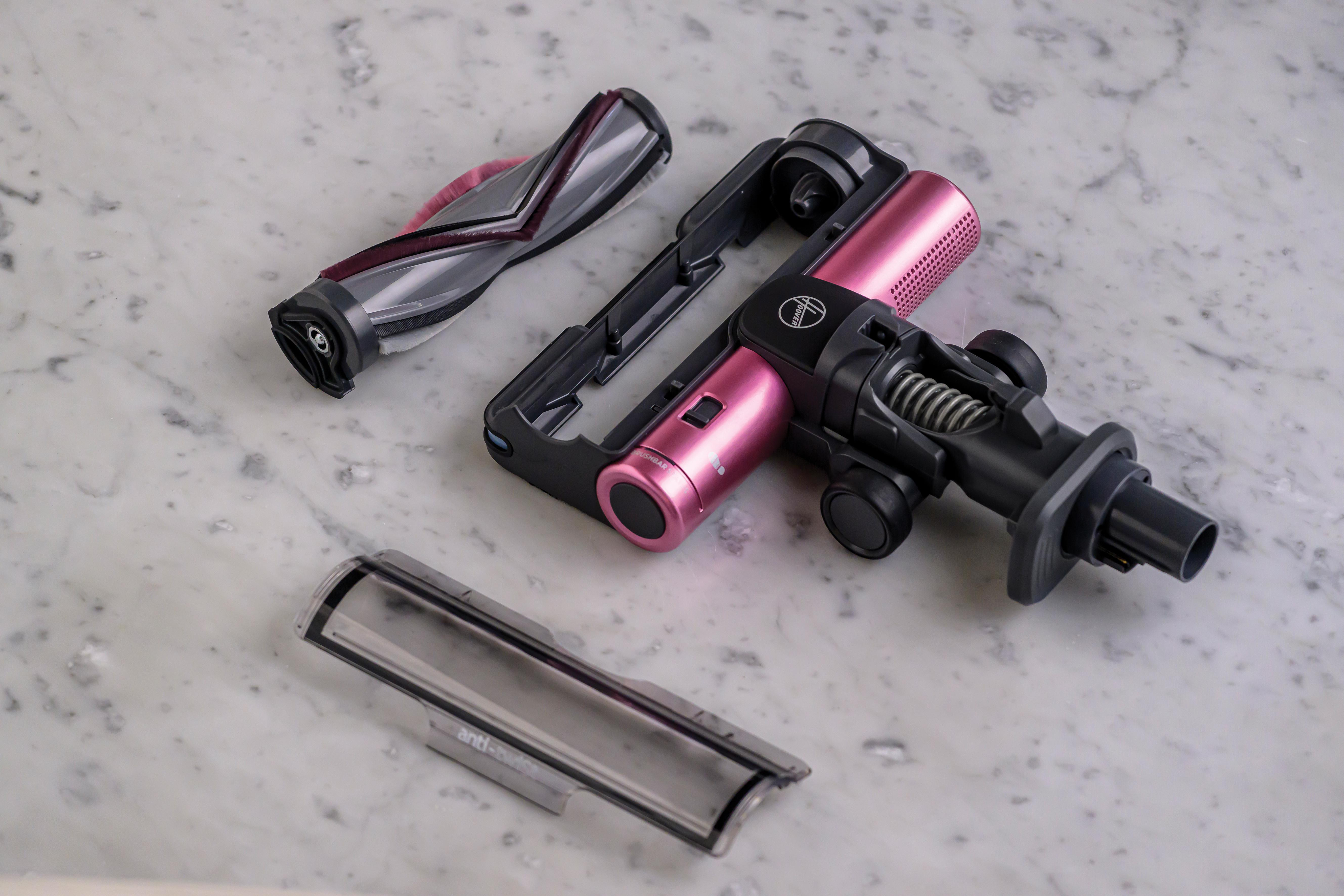 Zerlegte Staubsaugerteile: rosa Motor, Bürste und eine transparente Kunststoffabdeckung.