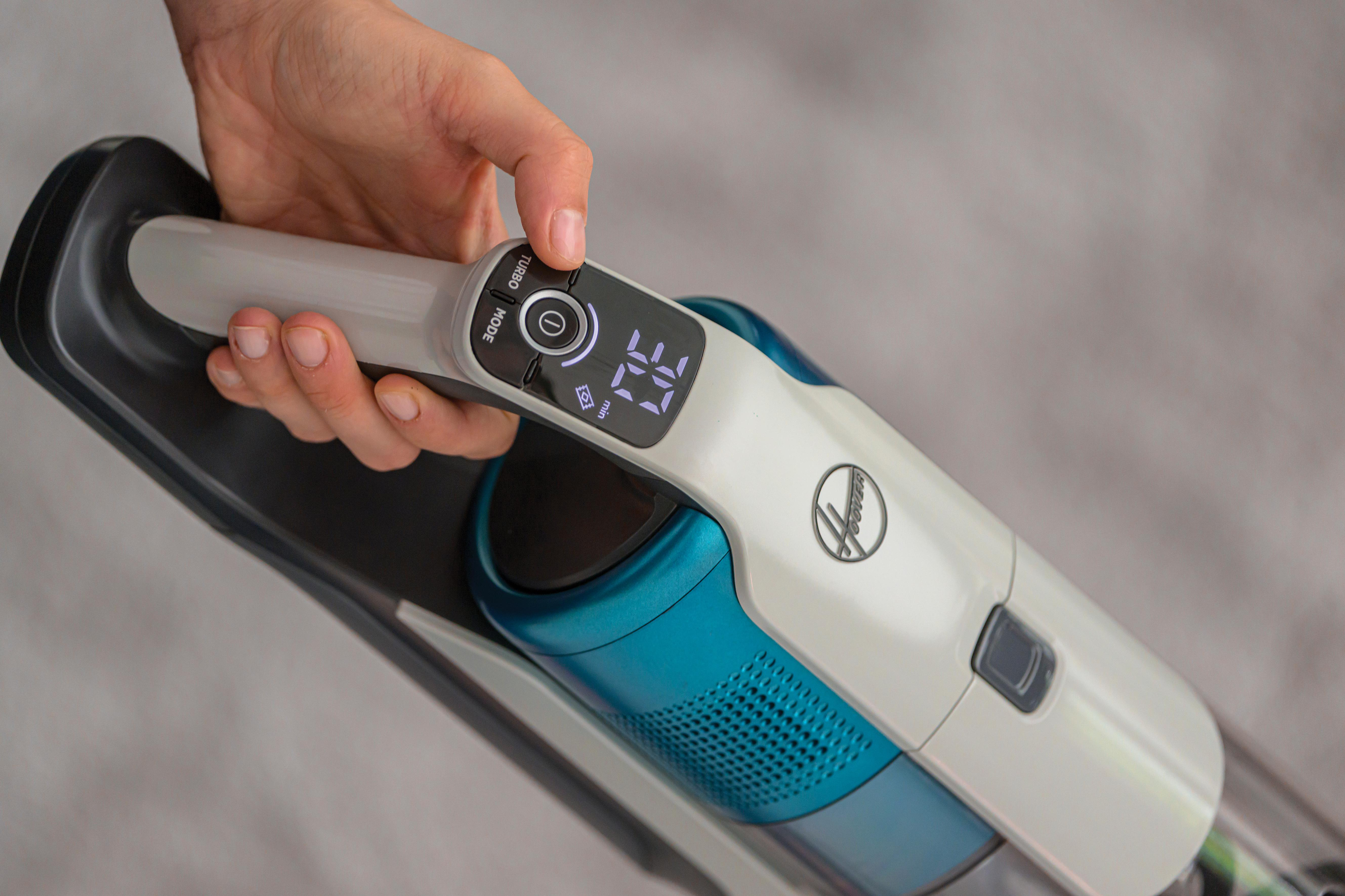 Hand einer Person, die einen Staubsauger mit Digitalanzeige bedient.