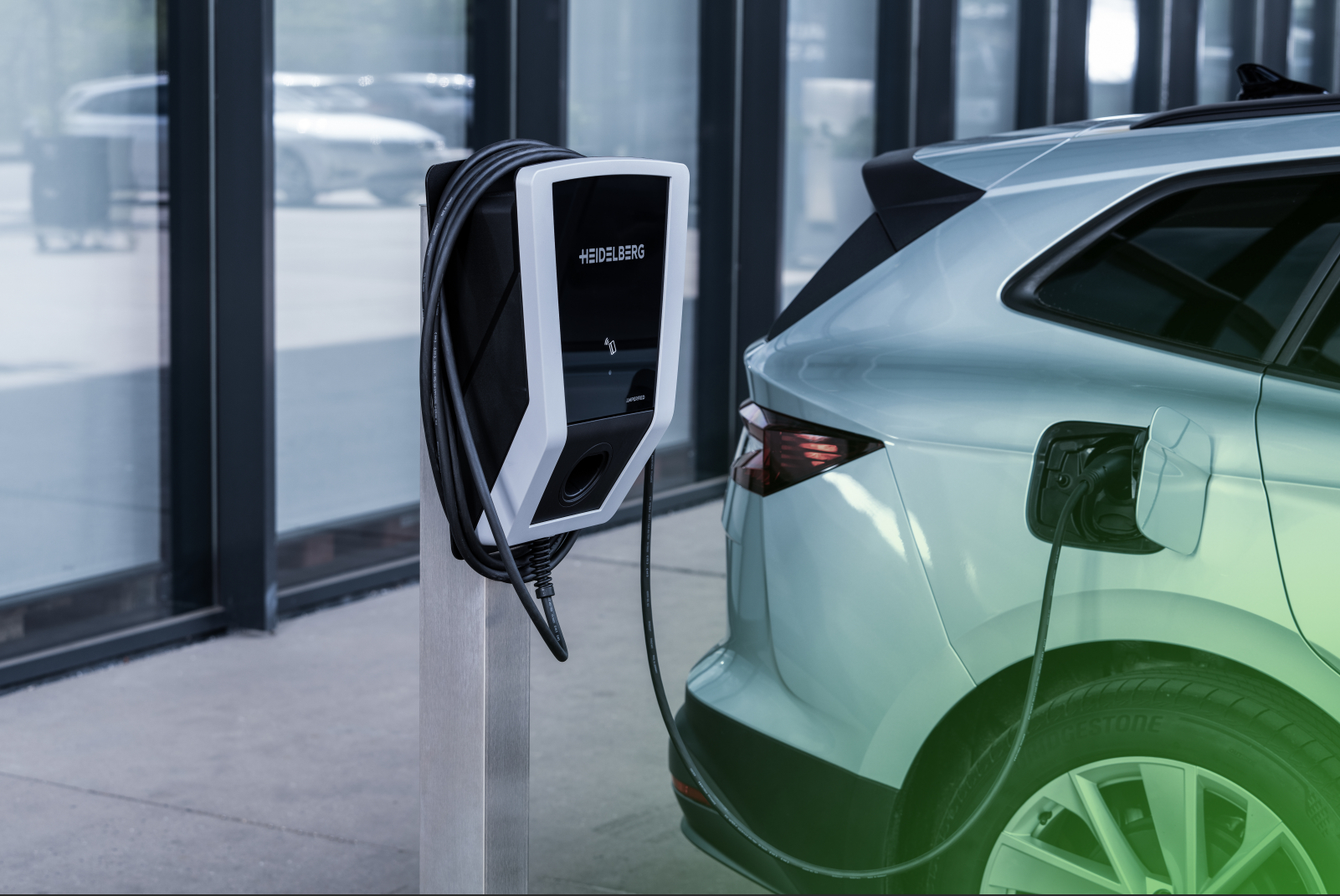 Ein Elektroauto, das an einer Ladestation angeschlossen ist, wobei die Station und das Auto im Fokus stehen.