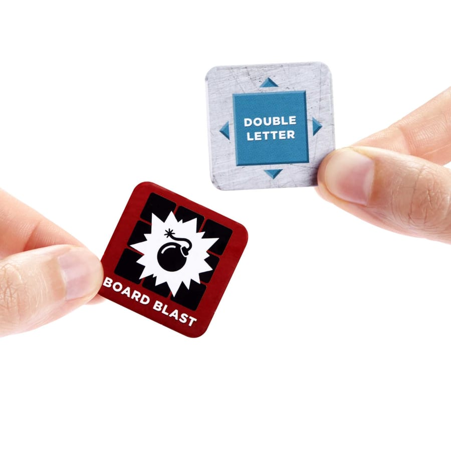 Hände halten Spielsteine. Einer ist rot mit Bomben-Icon, der andere blau.