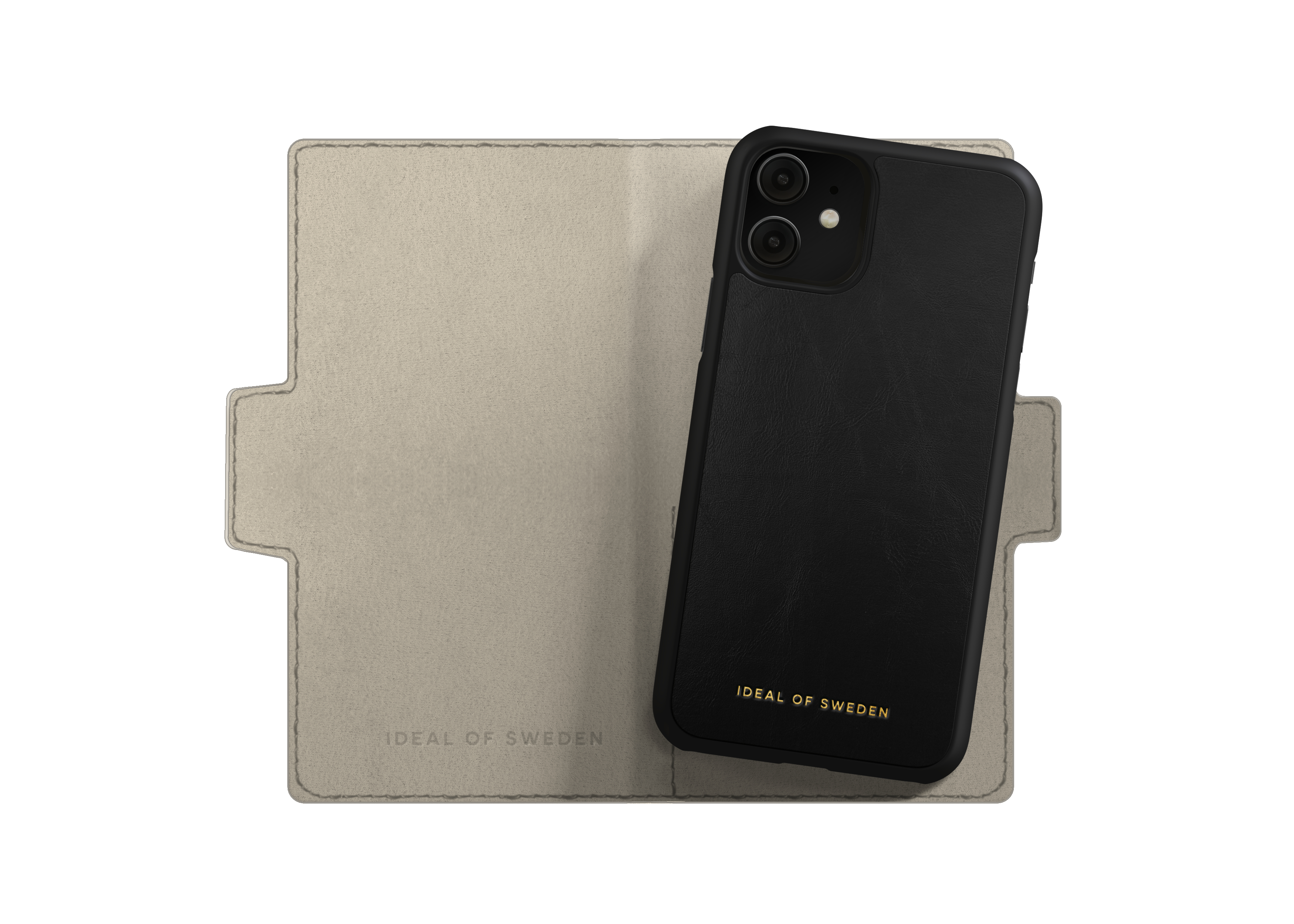 Schwarze Handyhülle auf beigem Folio. Telefon hat goldenen Text. Folio hat den Aufdruck "IDEAL OF SWEDEN".