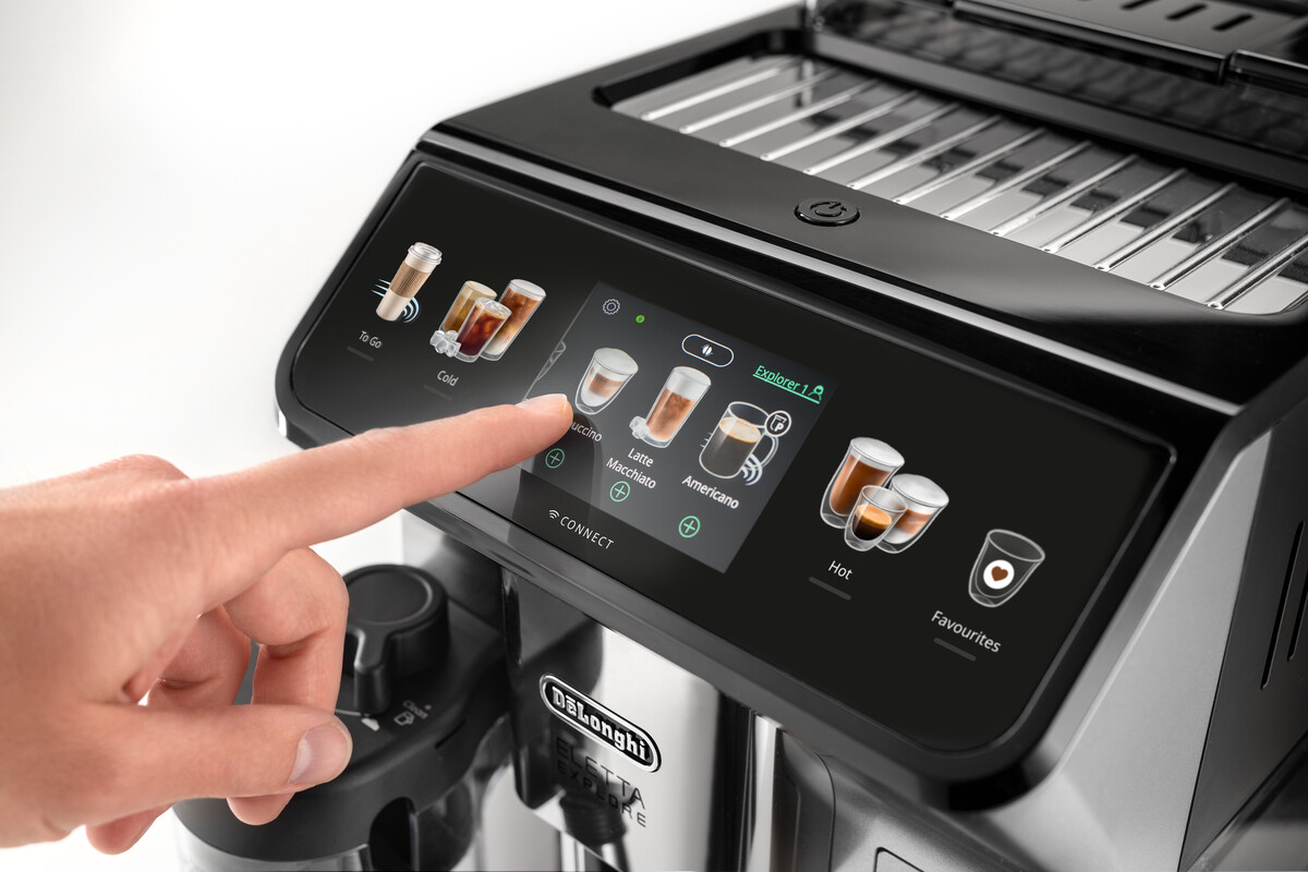 Interface van een koffiemachine, vinger raakt touchscreen, toont drankopties.