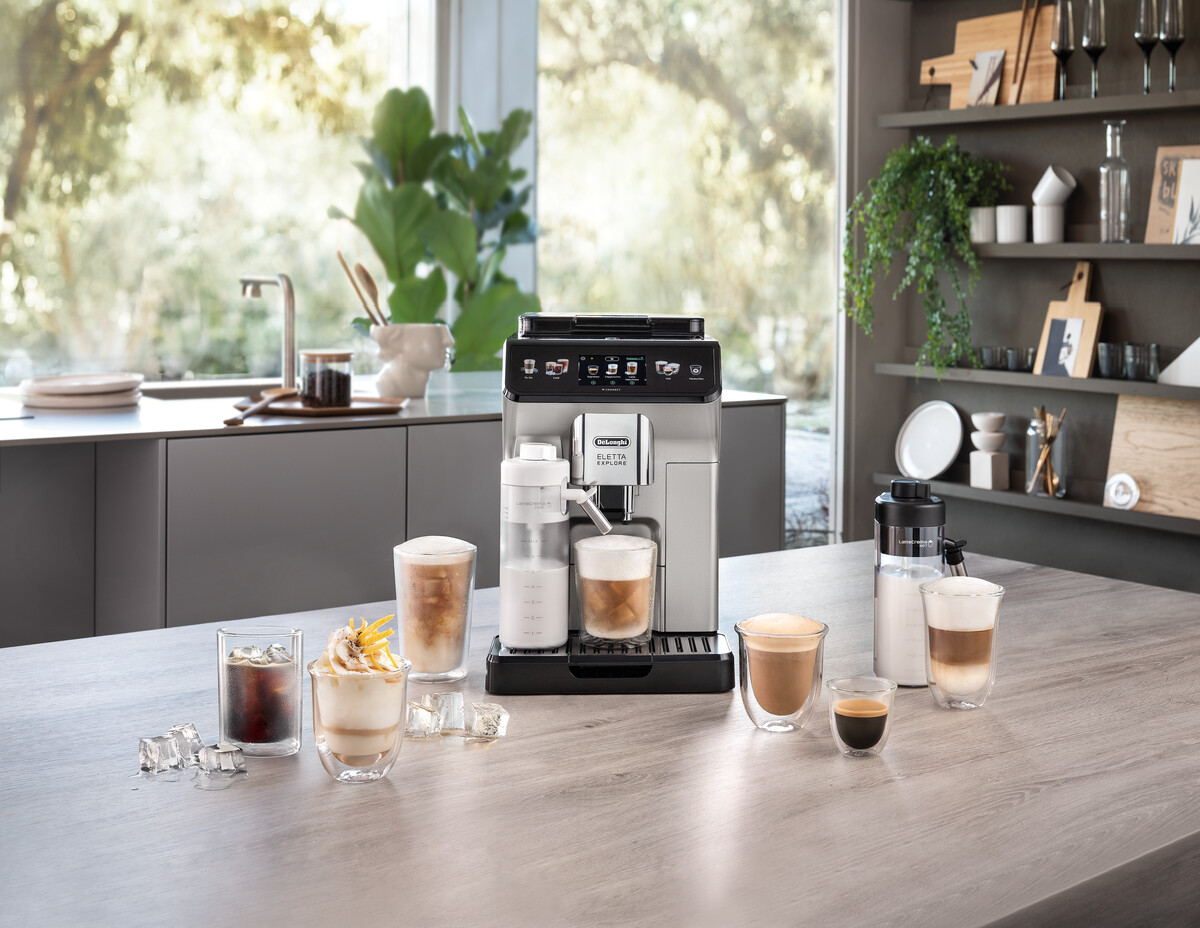 Koffiemachine met koffie- en melkdranken op een houten oppervlak.