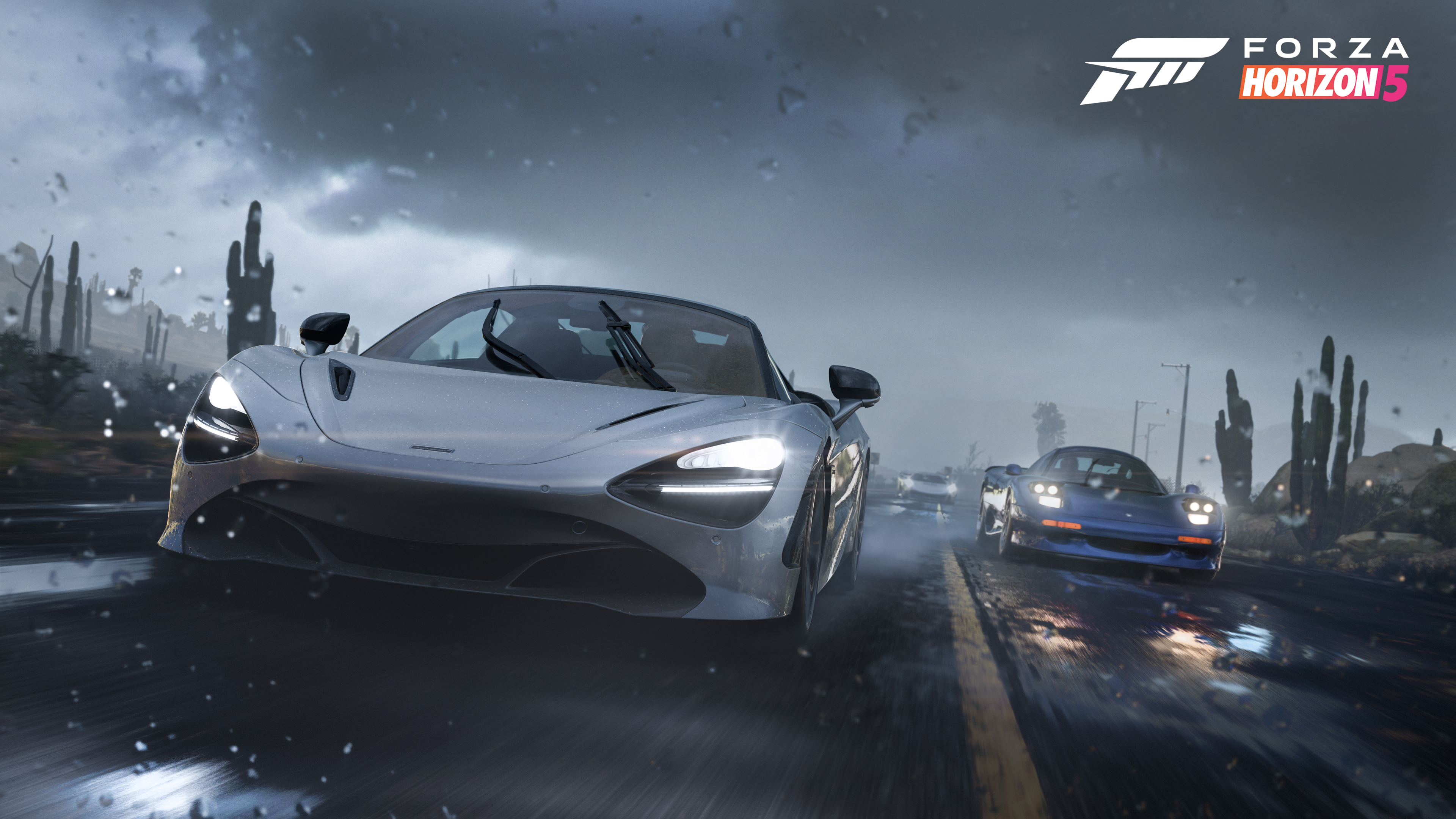 Dos coches compitiendo en Forza Horizon 5. Un McLaren plateado, el otro azul, en carretera mojada, fondo desértico.