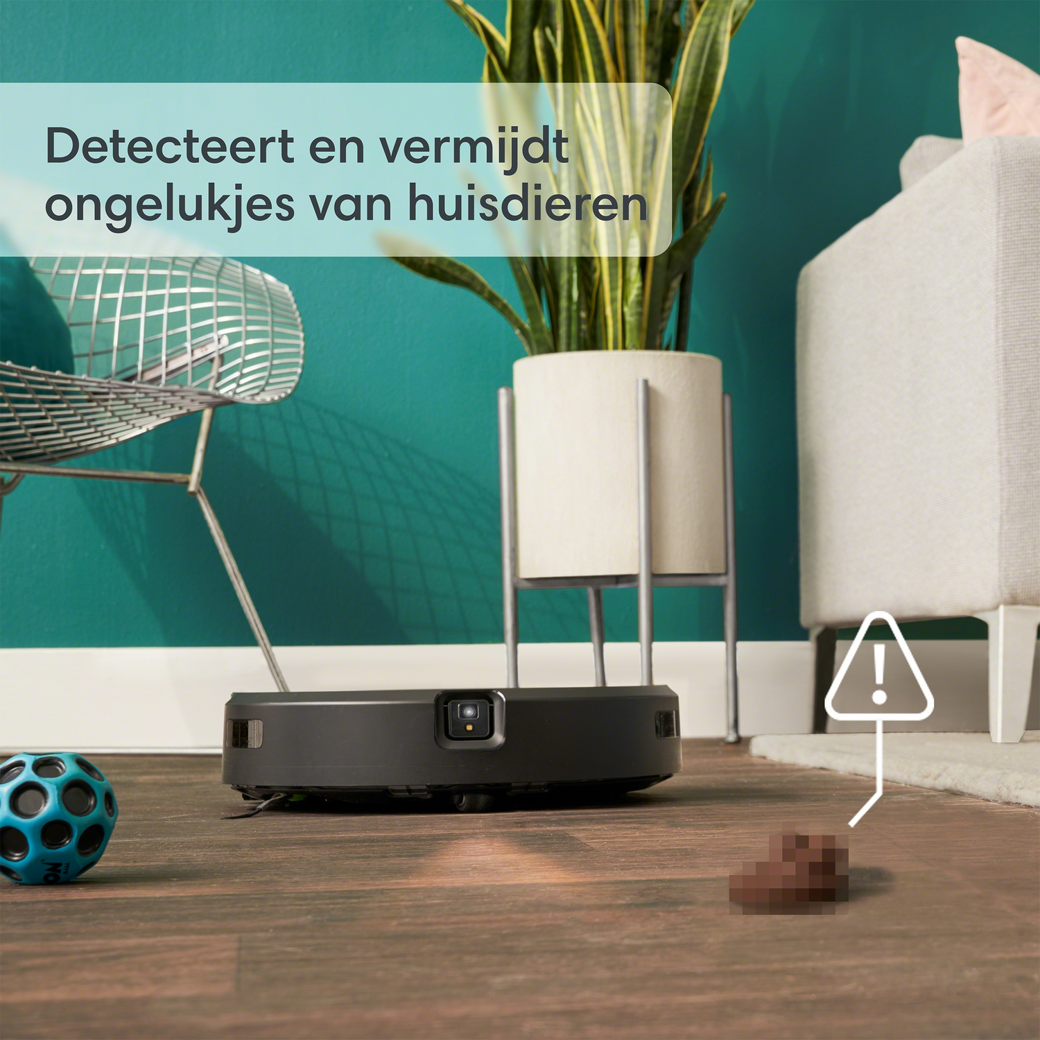 Een robotstofzuiger met een plant, een bal en een hoopje poep, op een houten vloer.