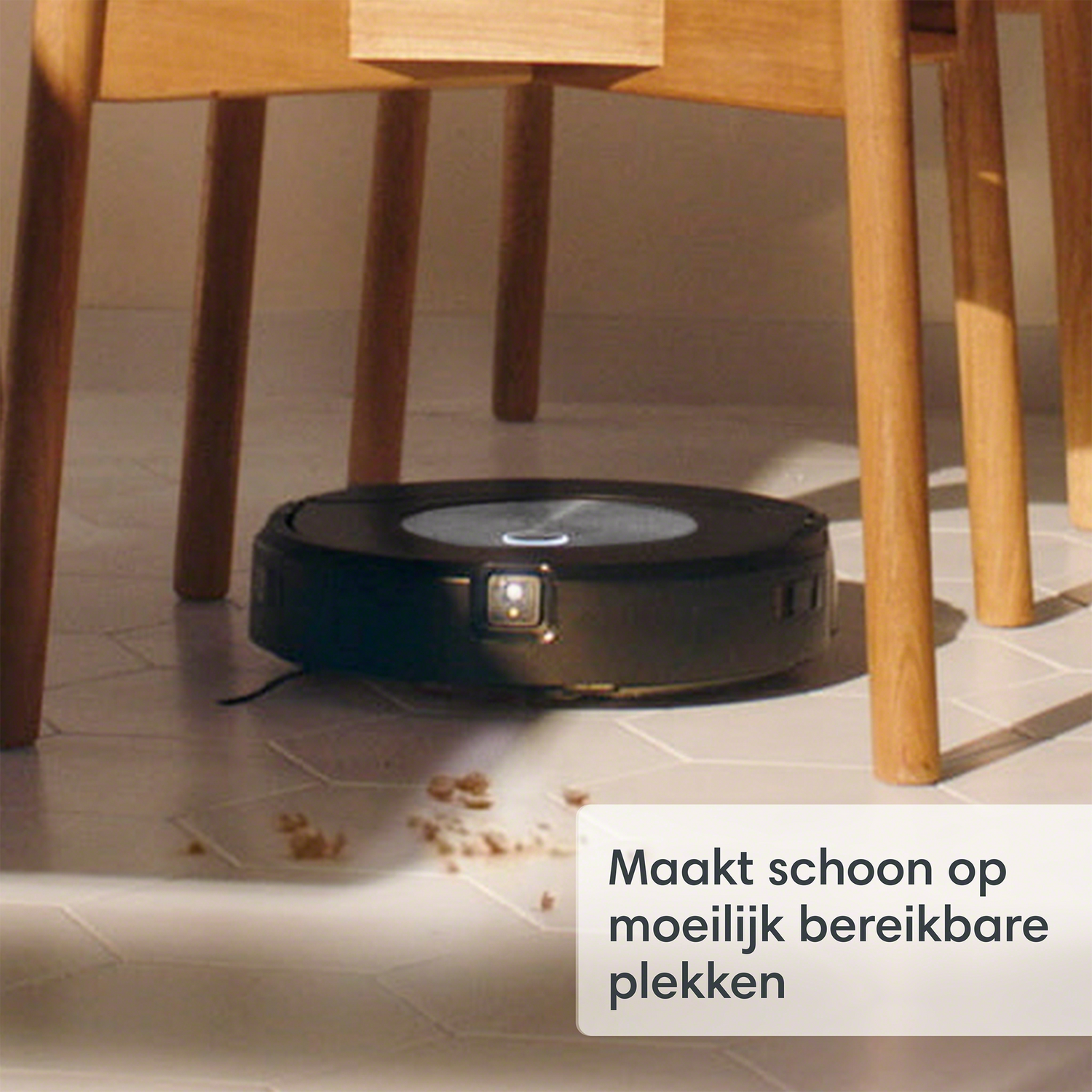 Zwarte robotstofzuiger op een witte tegelvloer.