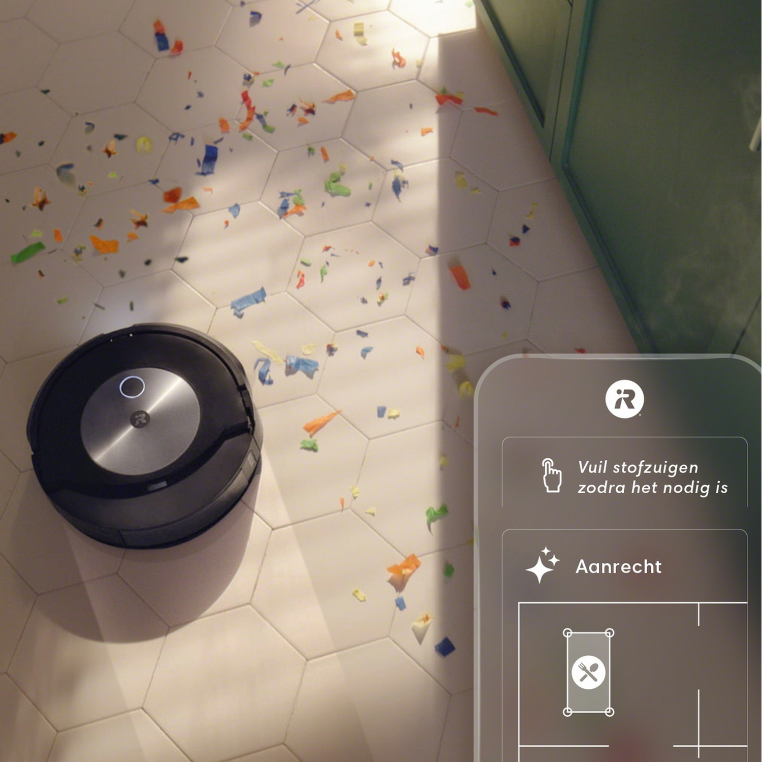 Een zwarte robotstofzuiger op een betegelde vloer bedekt met kleurrijke confetti.