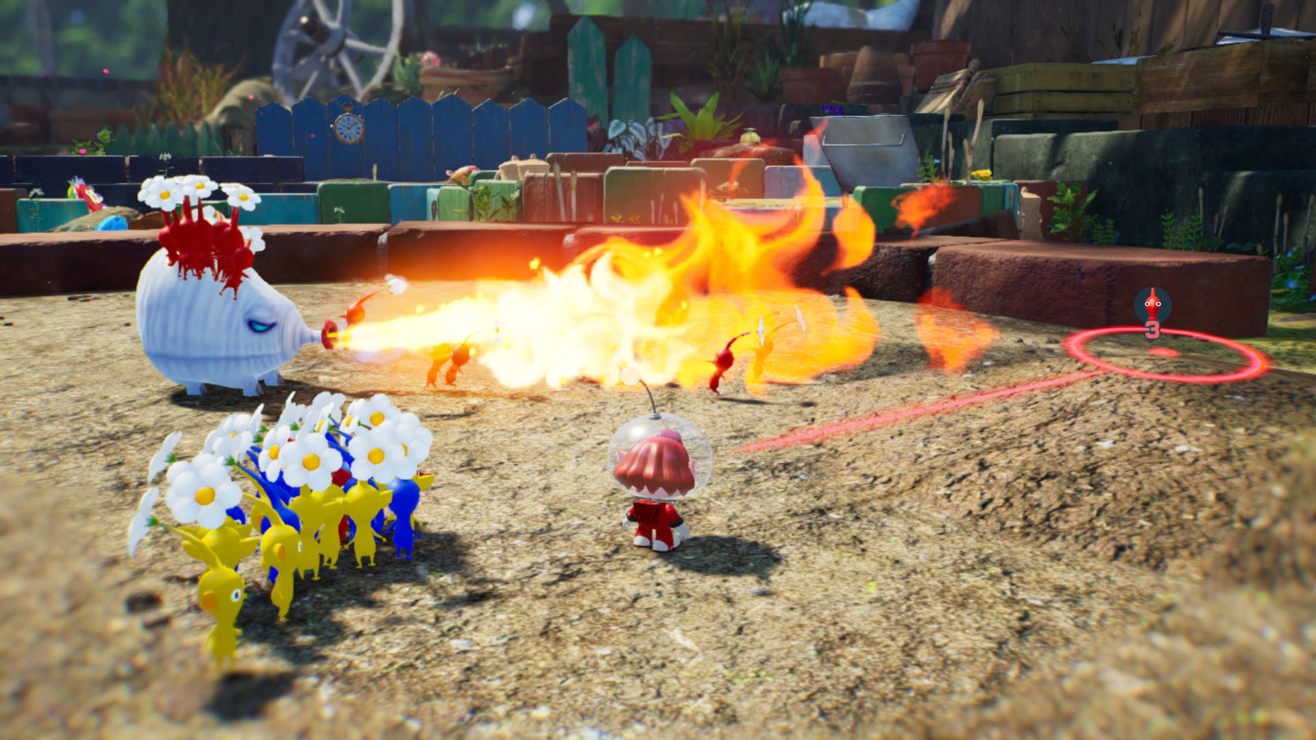 Una scena del gioco Pikmin con un grande nemico che spruzza fuoco sui Pikmin e un personaggio rosso.