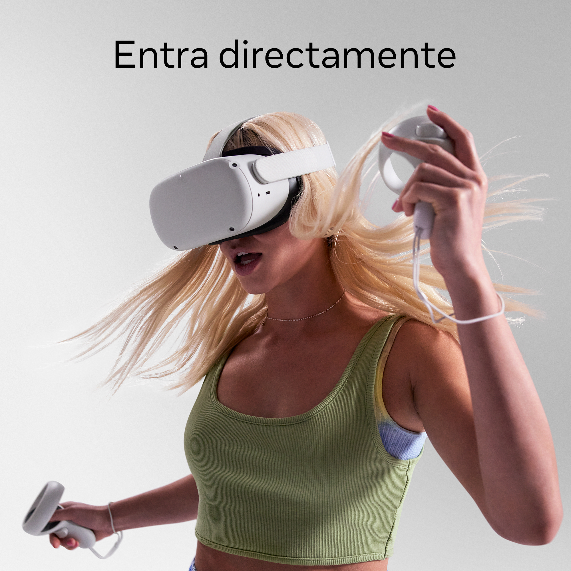 Mujer usando un casco de realidad virtual, sosteniendo mandos y gesticulando.