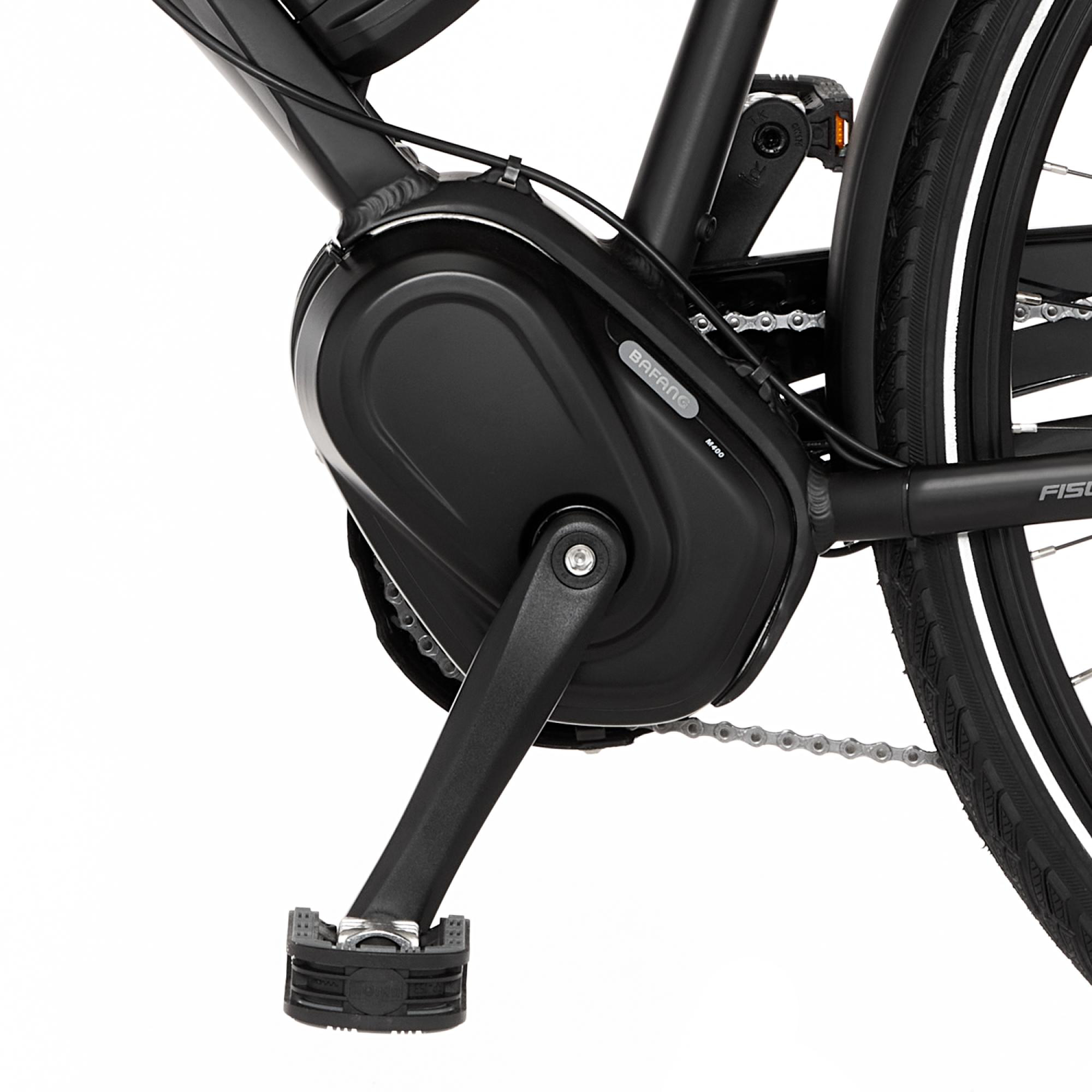 Nahaufnahme eines schwarzen Fahrradmotors und Pedale.