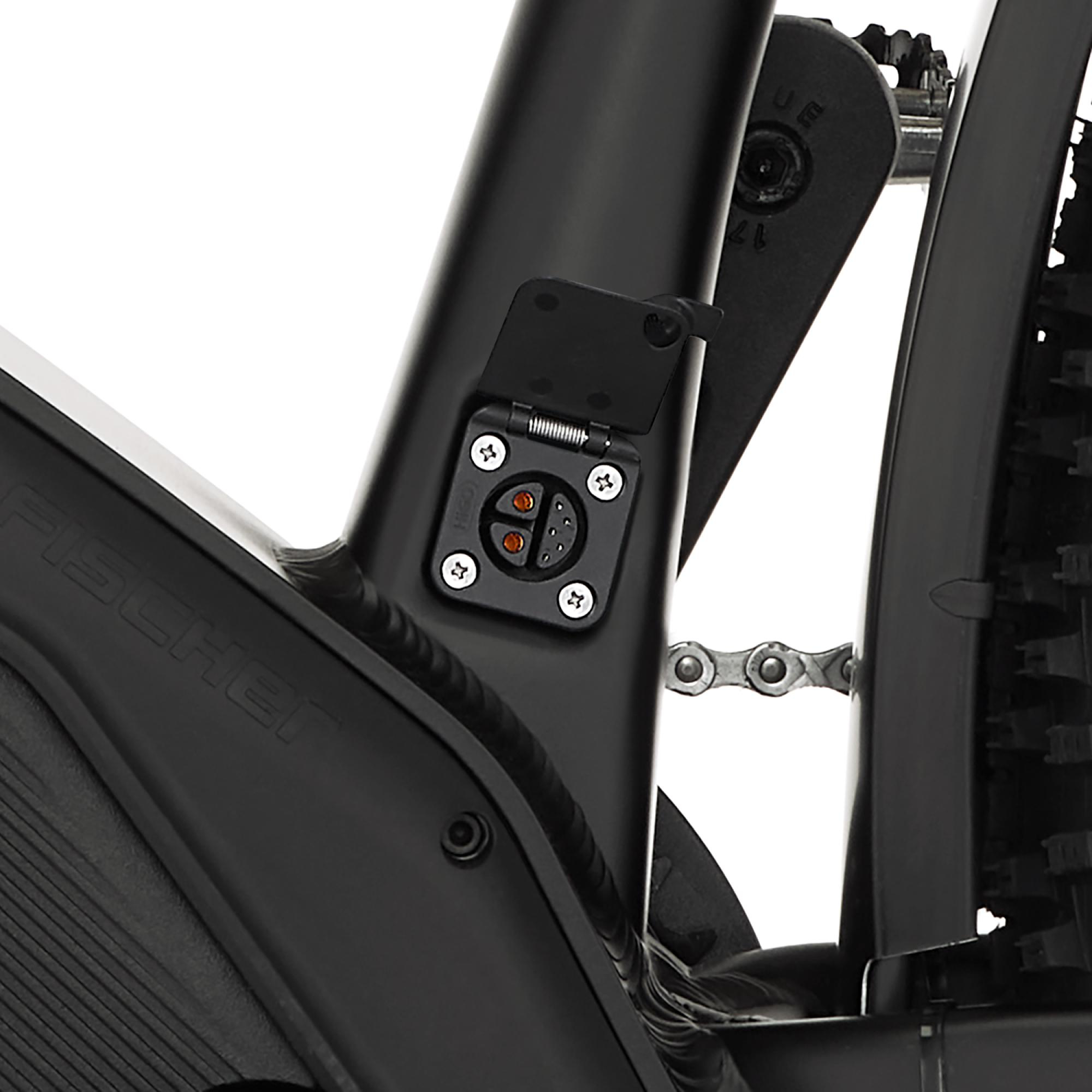 Nahaufnahme des Ladeanschlusses an einem schwarzen E-Bike-Rahmen. Der Anschluss ist von einer schwarzen Klappe bedeckt.
