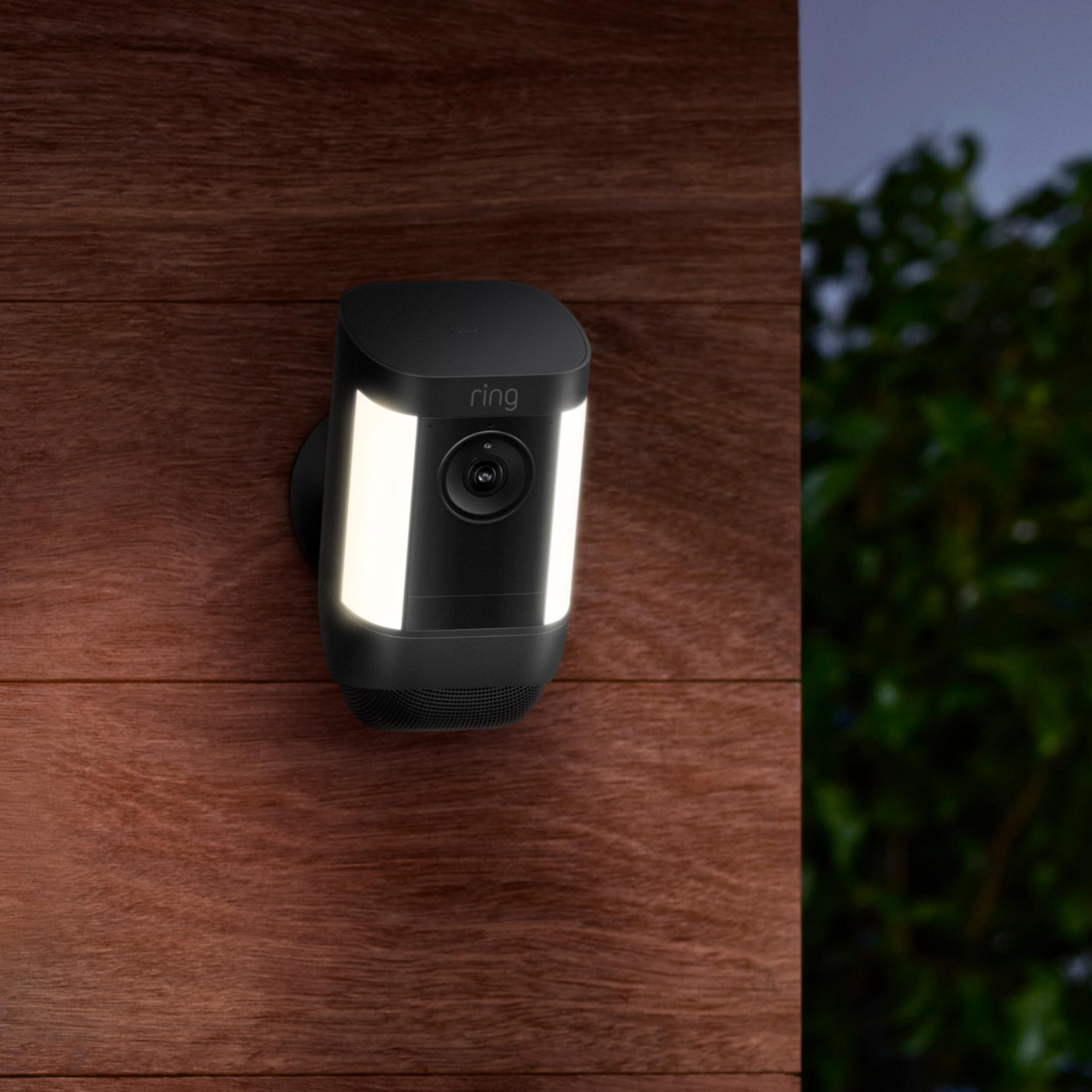 Eine schwarze Überwachungskamera, die an Holz mit einem Licht befestigt ist.