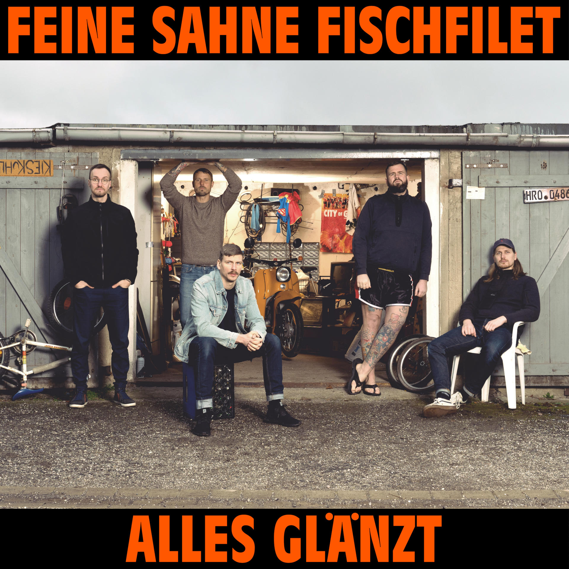Fünf Personen stehen vor einer Garage, Text oben und unten.