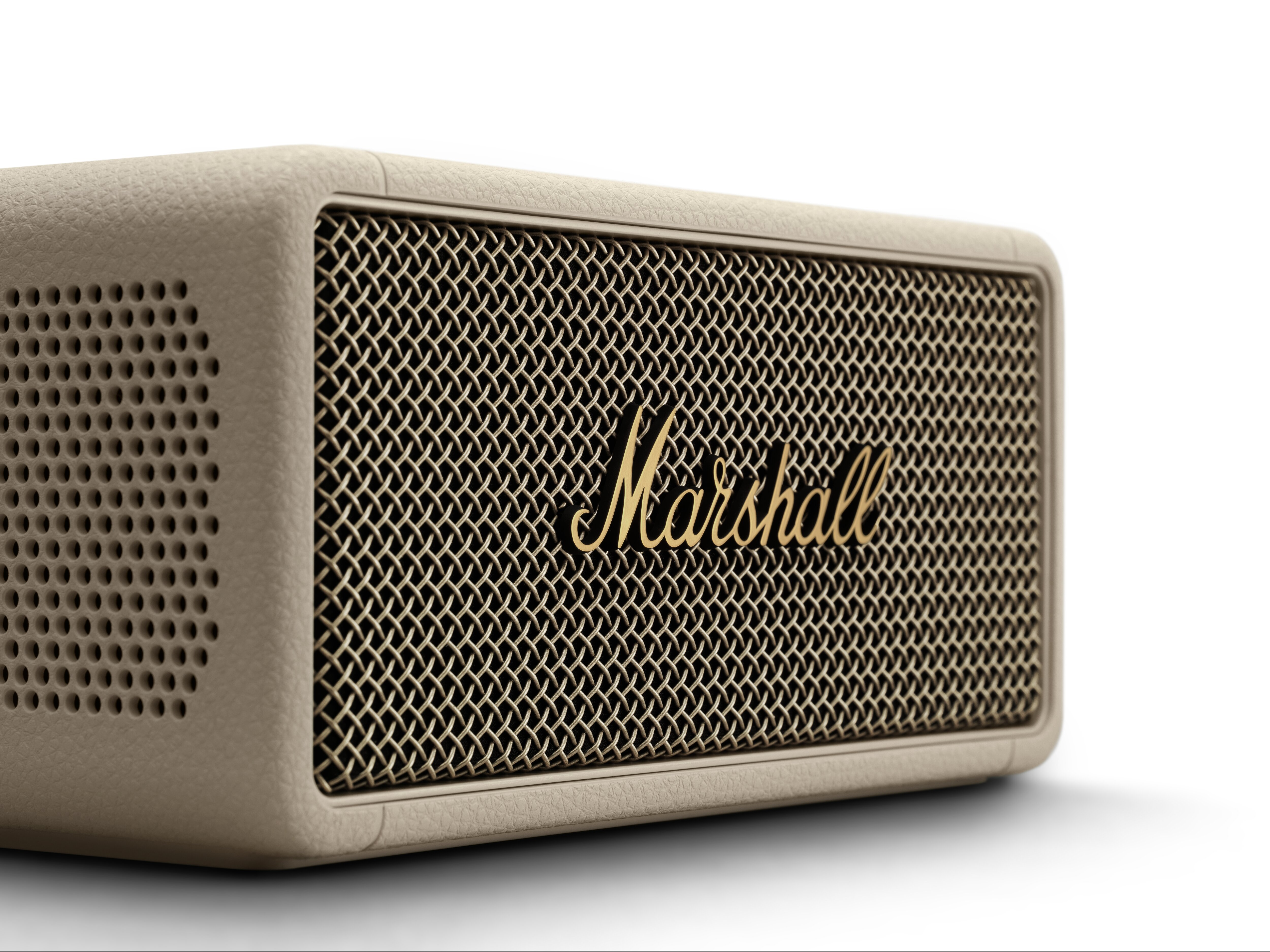 Nahaufnahme eines beigefarbenen Marshall-Lautsprechers mit goldfarbenem Gitter und Logo auf weißem Grund.
