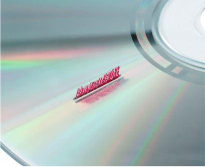 Nahaufnahme einer CD mit Reinigungsbürste; reflektierende Oberfläche.
