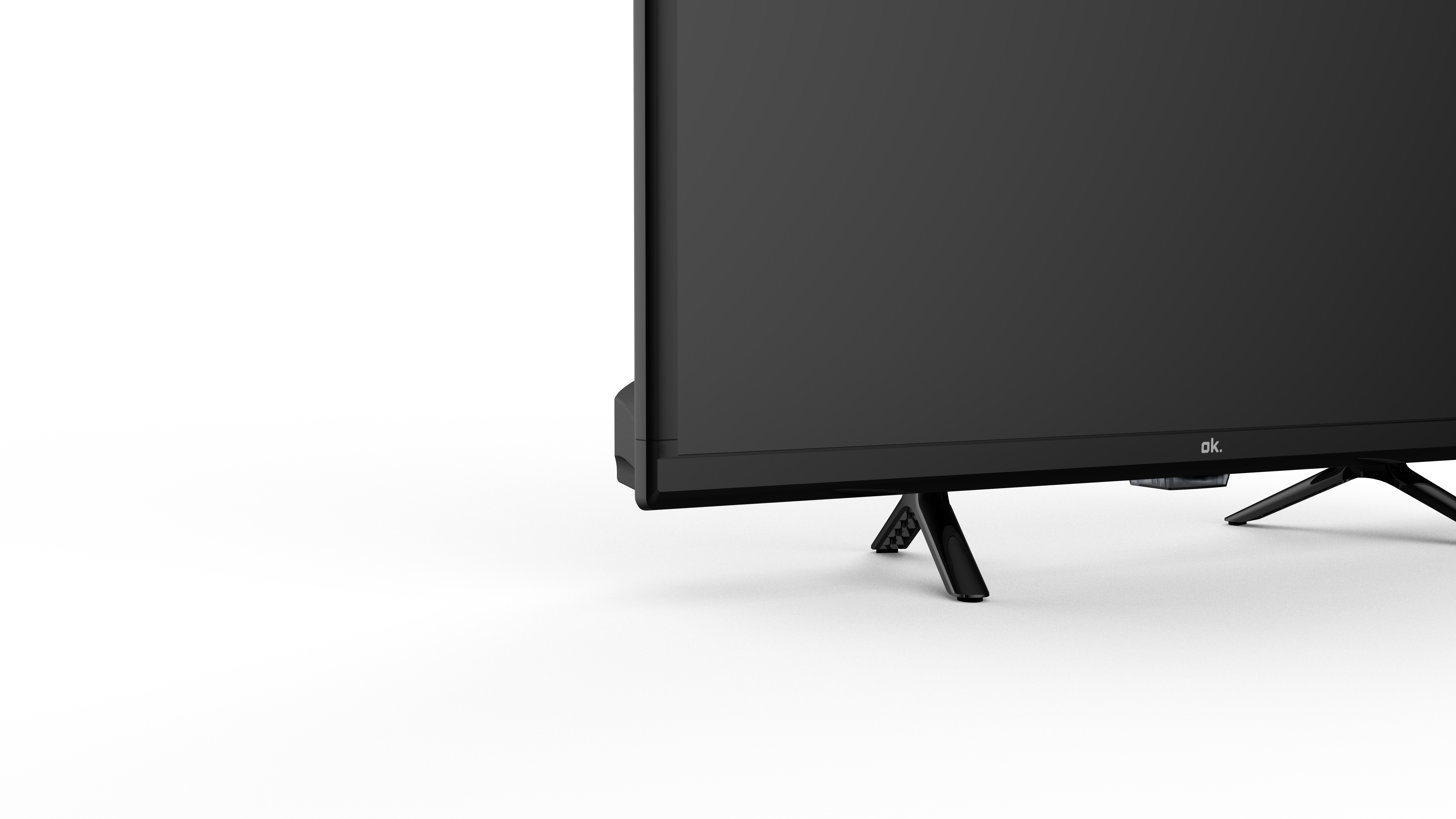 Vista de ángulo bajo de una pantalla de televisión negra sobre un fondo blanco, soportada por patas negras.