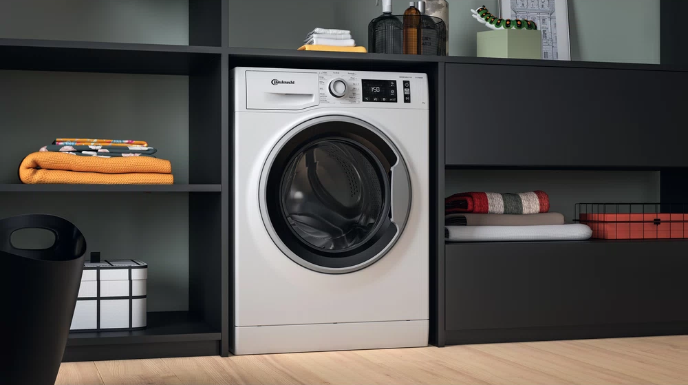 Machine à laver encastrée dans un meuble. Façade blanche avec porte noire et meuble noir.