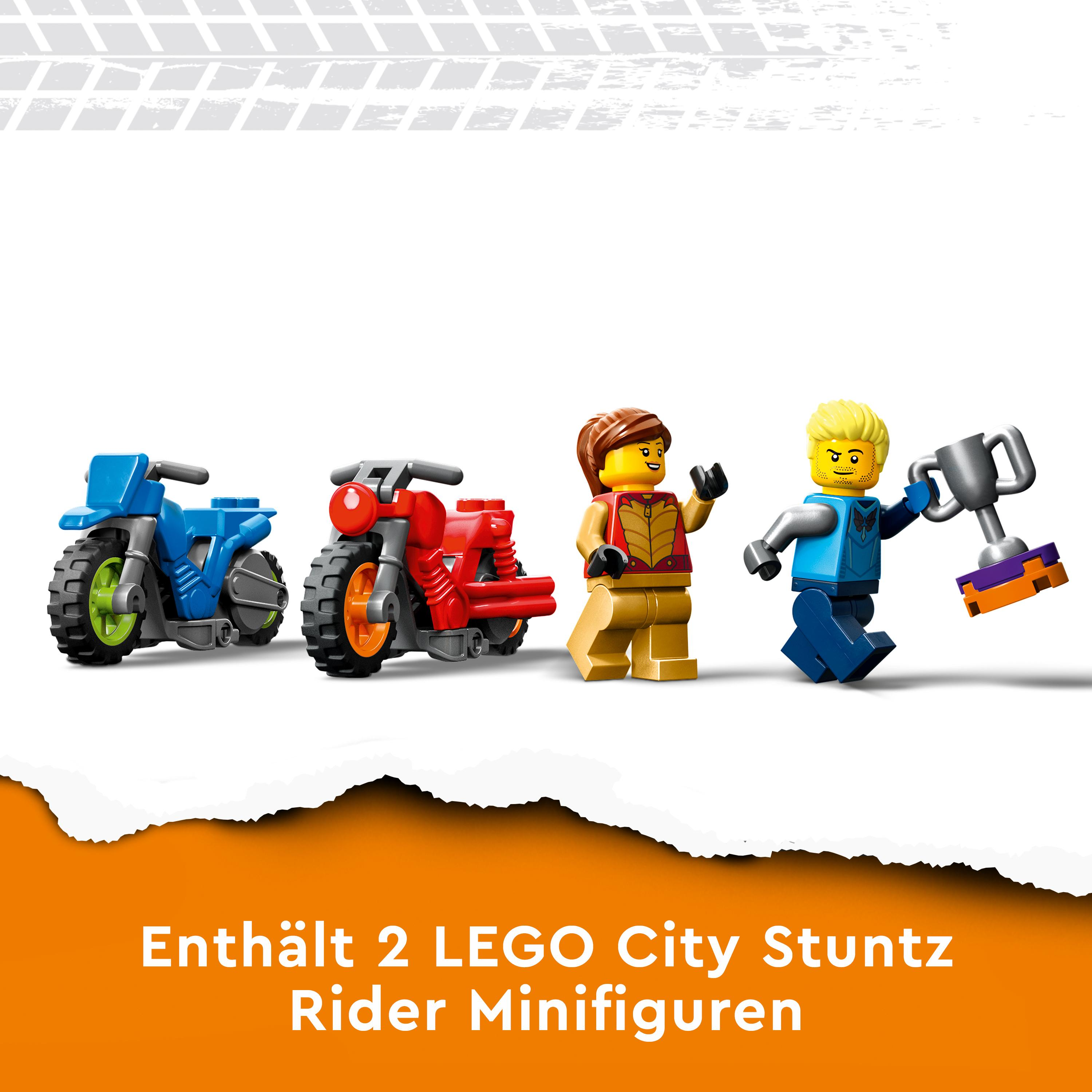 Zwei Lego City Stunt-Motorräder und zwei Minifiguren, eine mit Trophäe, stehen vor weißem Hintergrund.