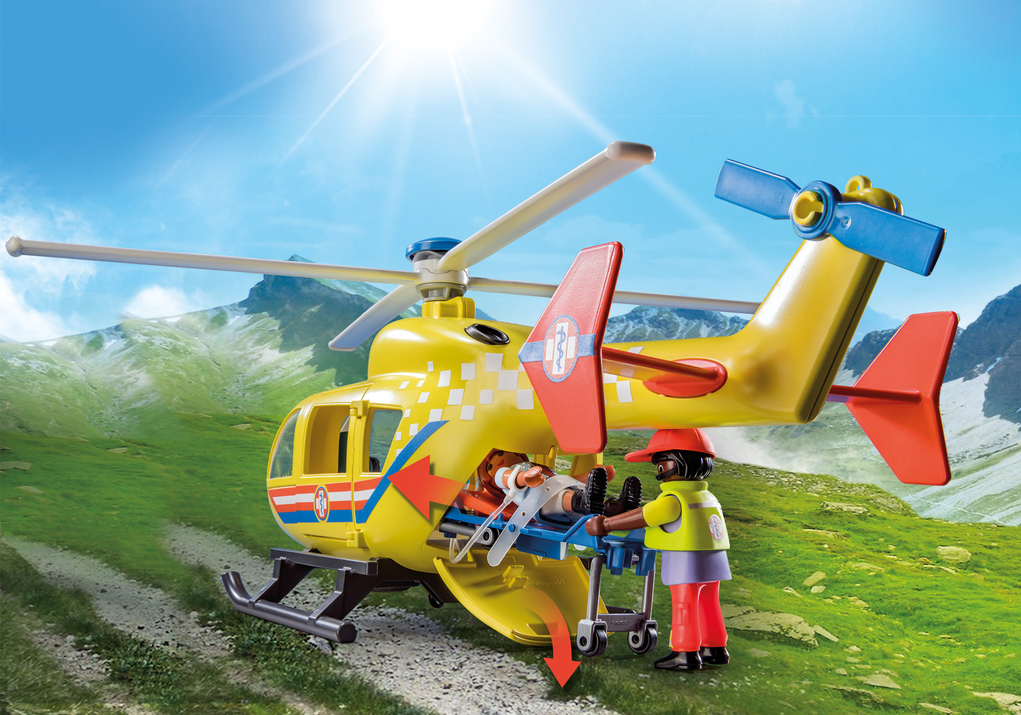 Gelber und weißer Playmobil-Hubschrauber mit Trage und zwei Figuren vor einer Bergkulisse.