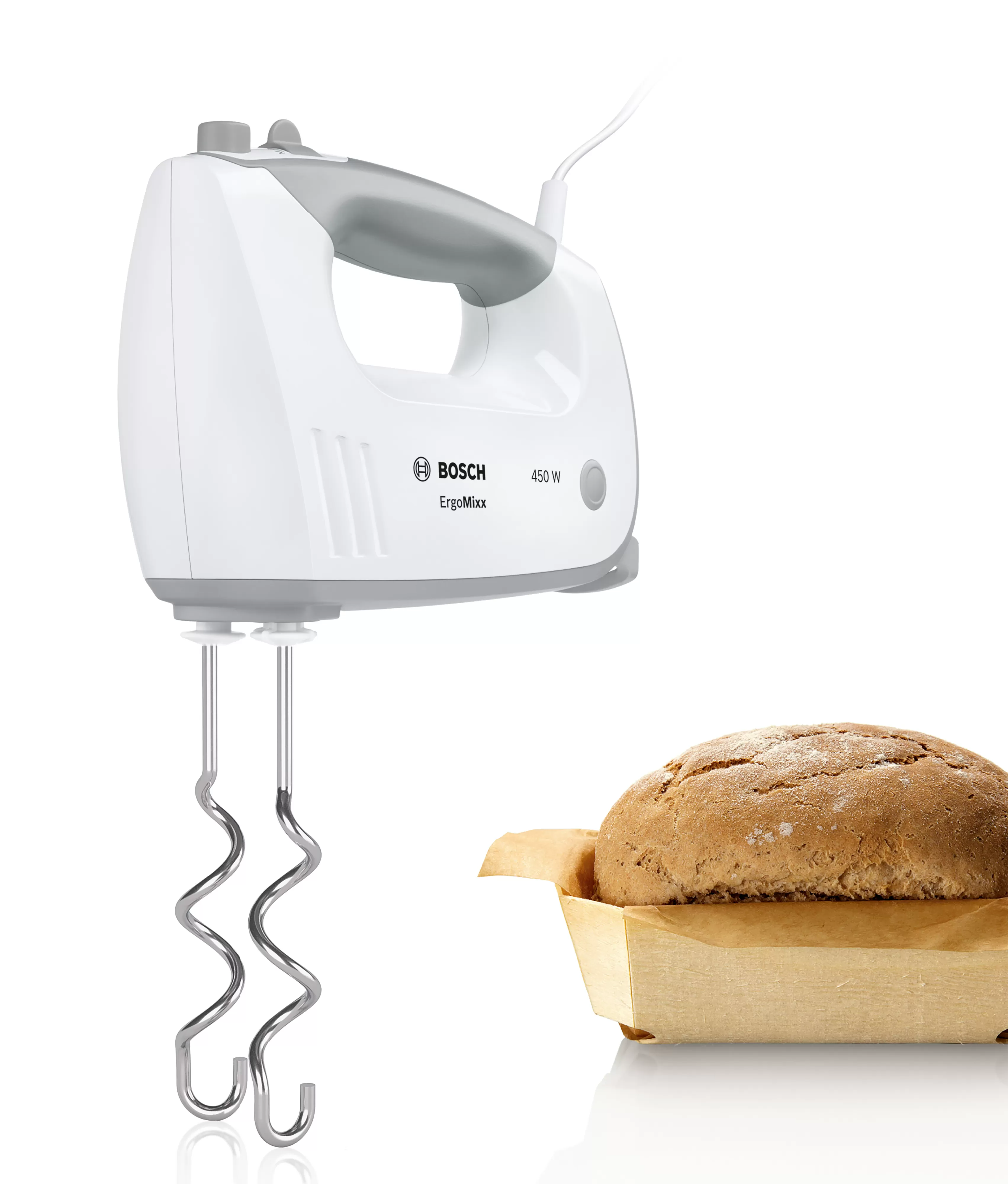 Fehér Bosch kézi mixer ezüst habverőkkel. Kenyér egy fa tálcán. Fehér háttér.