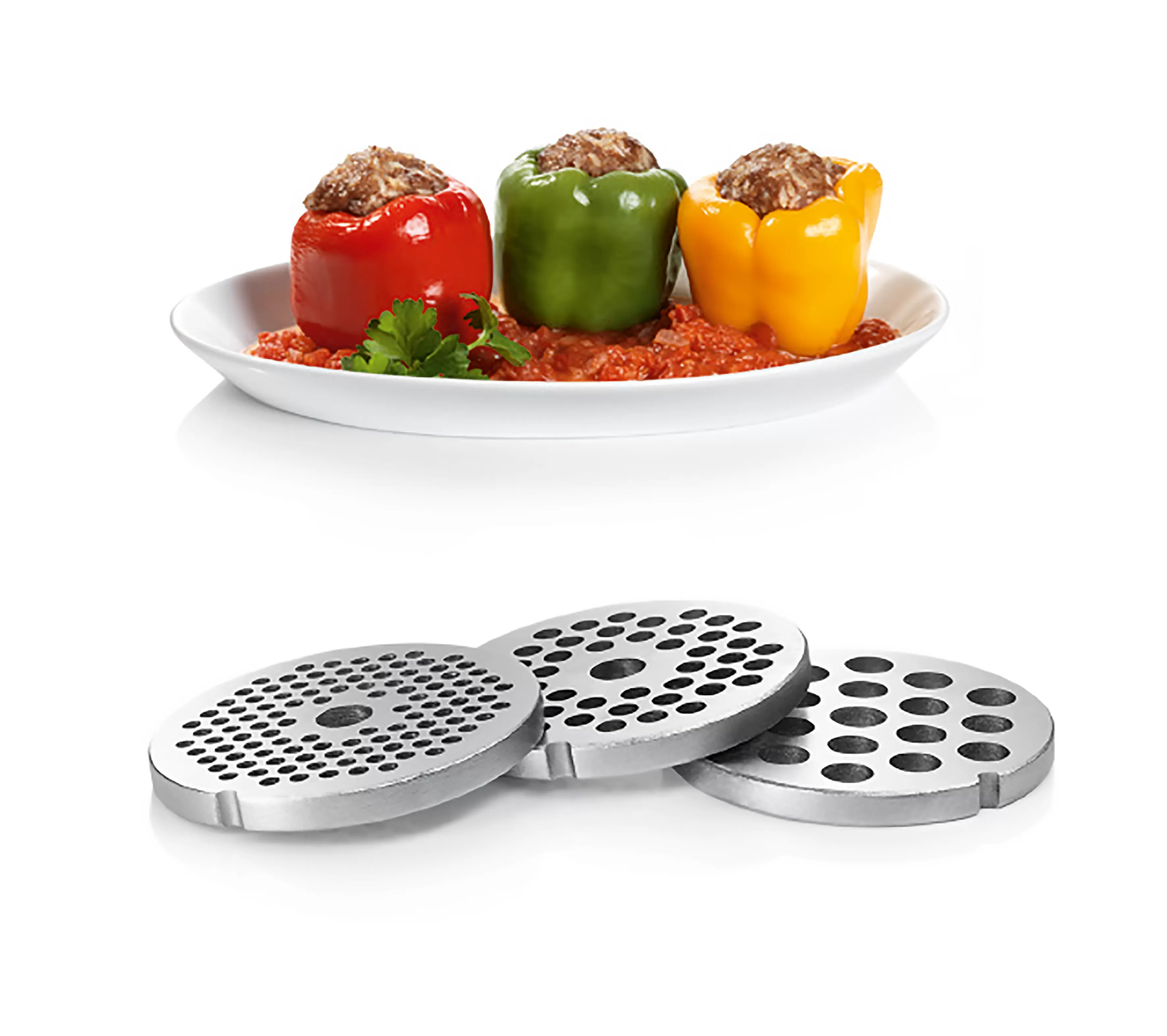 Három töltött paprika a tányéron, alatta fém darálólemezekkel.