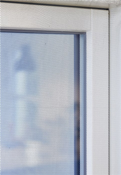 Primer plano de una ventana con una mosquitera instalada.