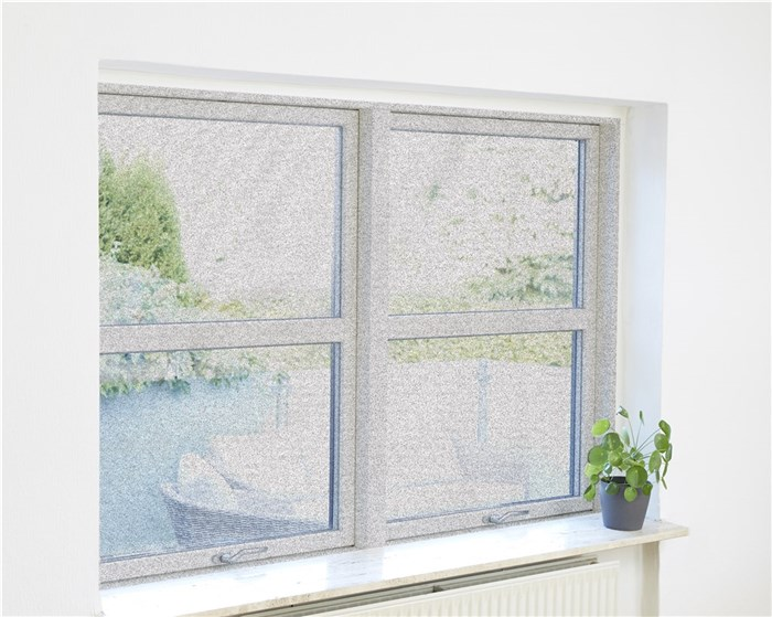 Ventana con vista a jardín verde. Una planta en el alféizar.