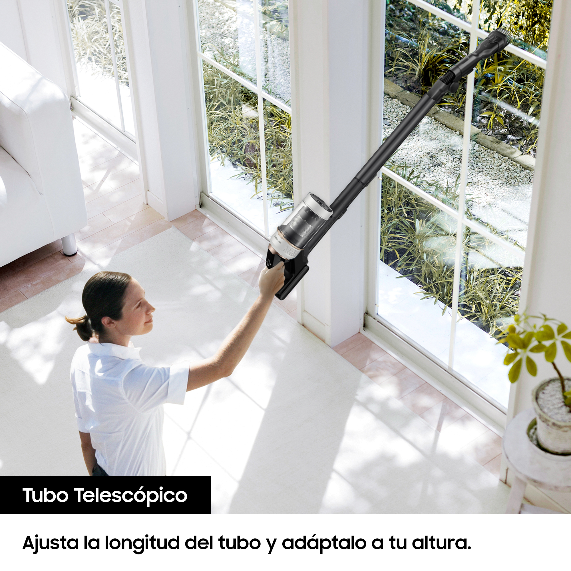 Mujer aspirando una ventana con una aspiradora inalámbrica. Texto 'Tubo telescópico'.