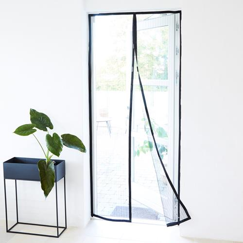 Una puerta blanca con una pantalla de malla negra, una planta en maceta a la izquierda y una vista exterior.