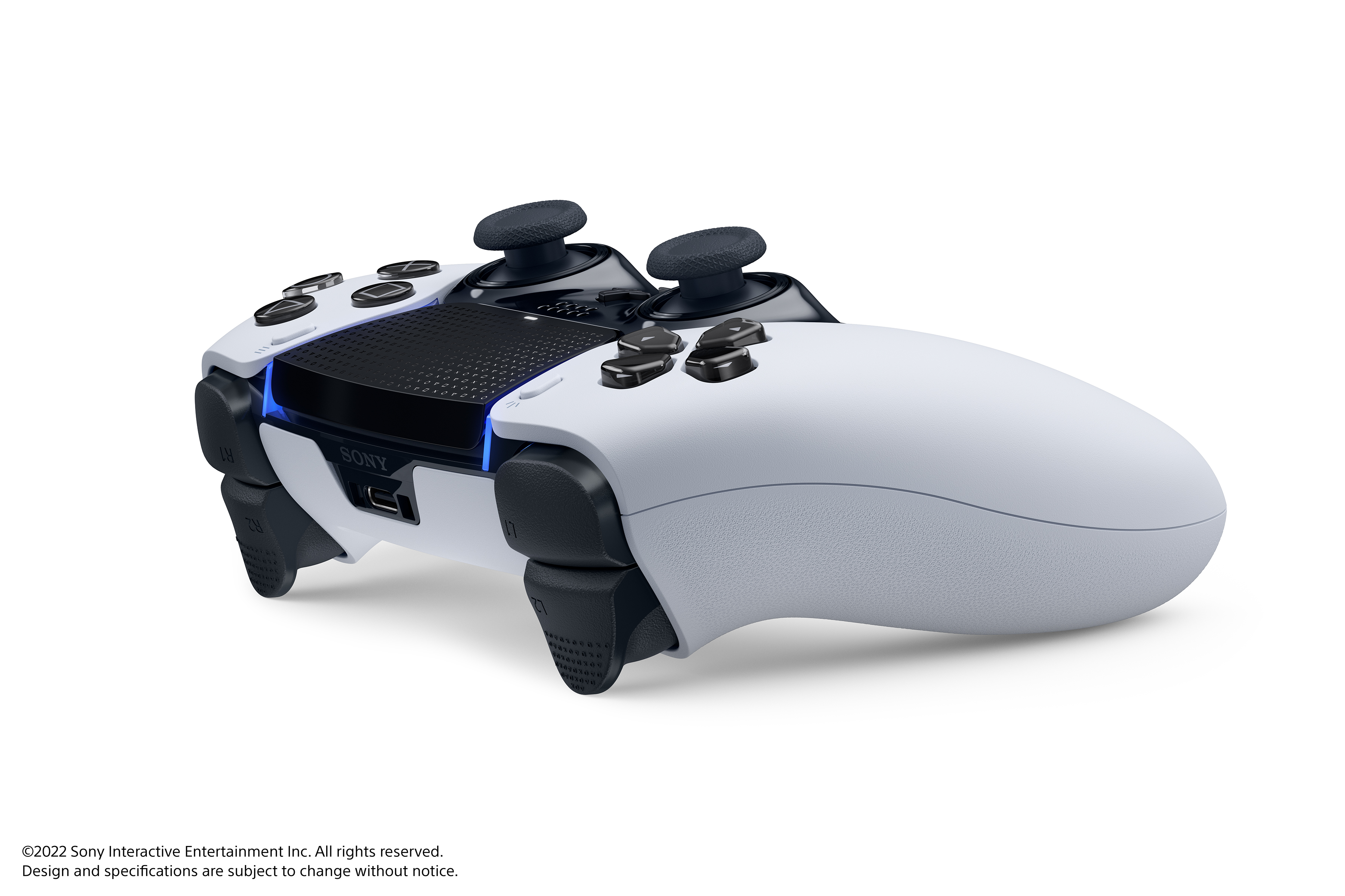 Ein weiß-schwarzer Game-Controller mit Knöpfen und Joysticks auf weißer Oberfläche.