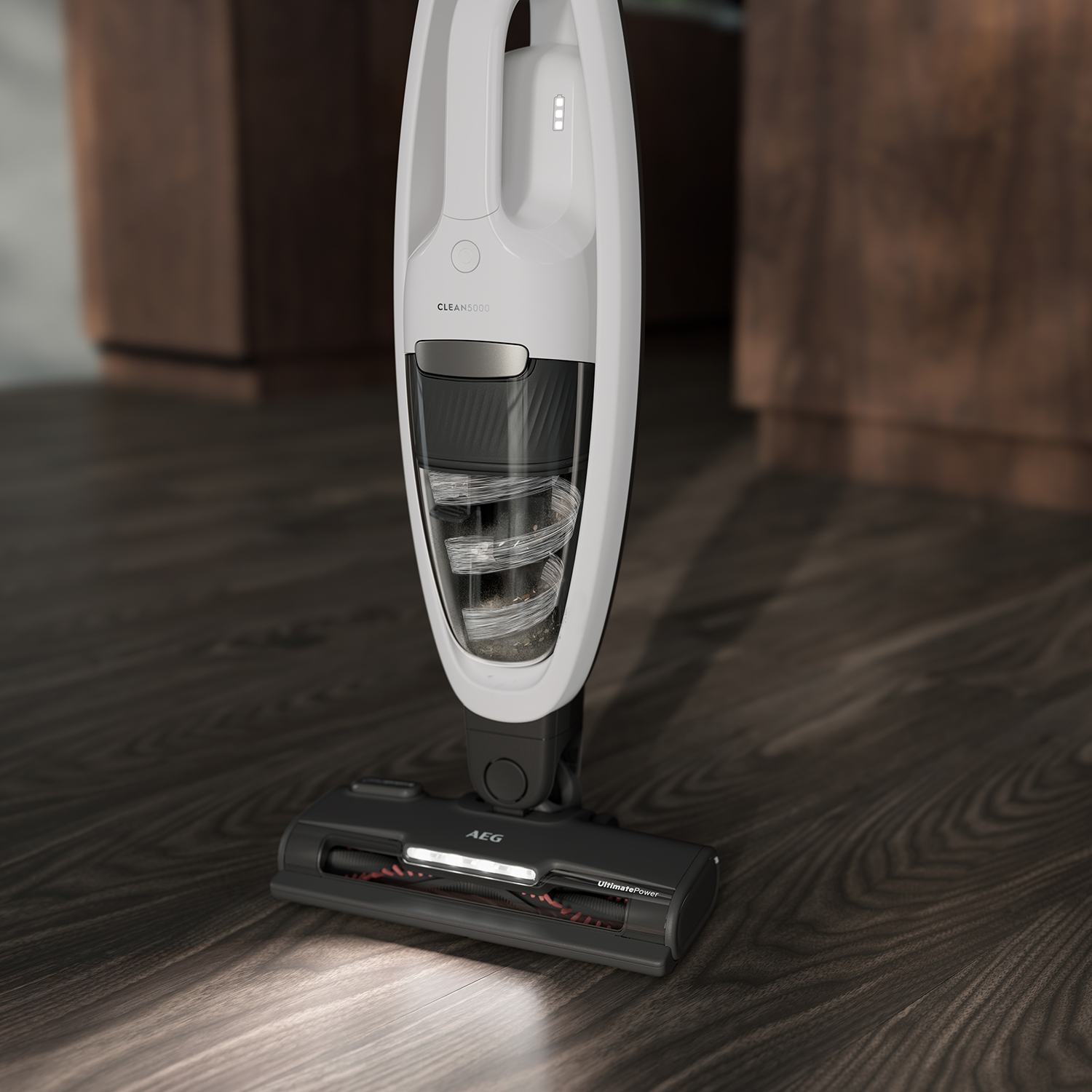 White and silver cordless vacuum cleaner on wooden floor, showing brush head and details.