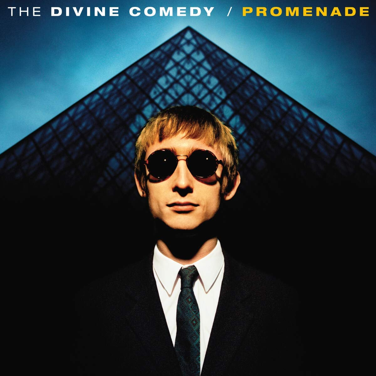 A Divine Comedy album borítója, napszemüveges férfi egy épület előtt.