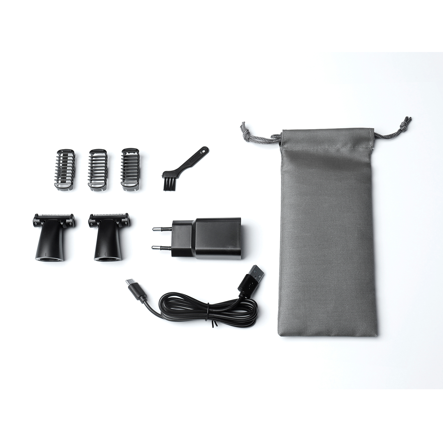 Accessori per un kit di toelettatura su una superficie bianca. Include testine del trimmer, spazzola, caricatore e custodia.
