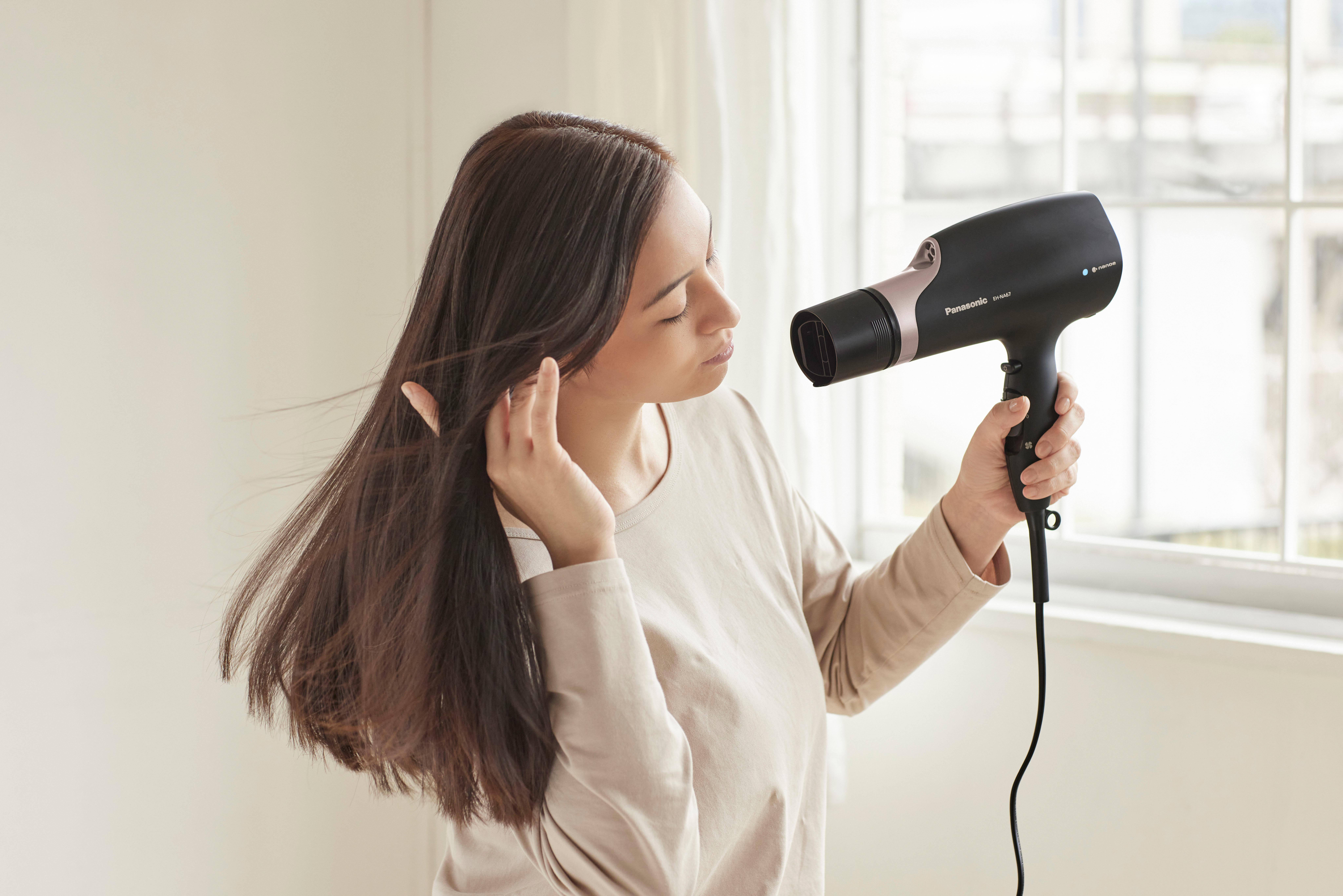 Nahaufnahme eines hellgrünen Philips Open-Ear-Kopfhörers auf grünem Hintergrund.