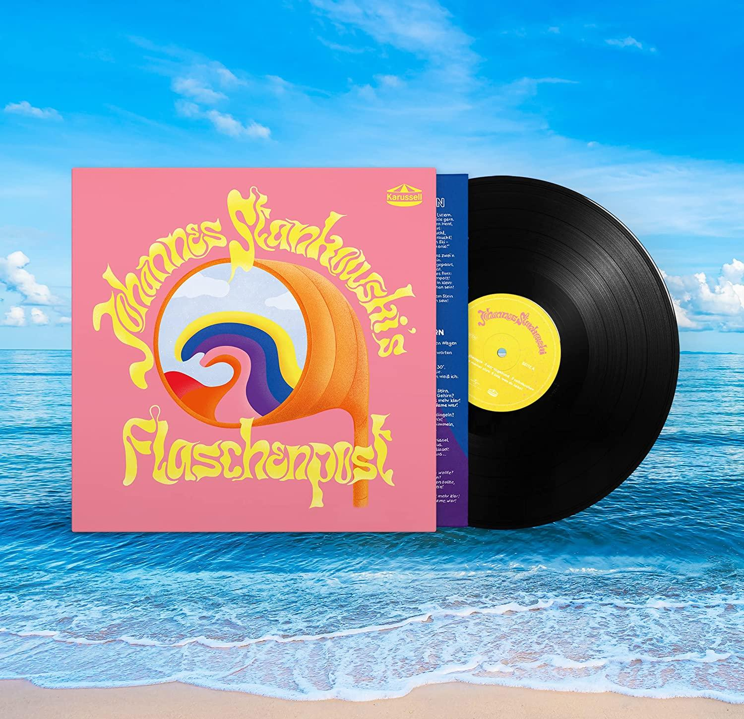 Vinyl-Schallplatte und Hülle. Das Cover ist rosa mit farbenfrohem Design, am Strand.