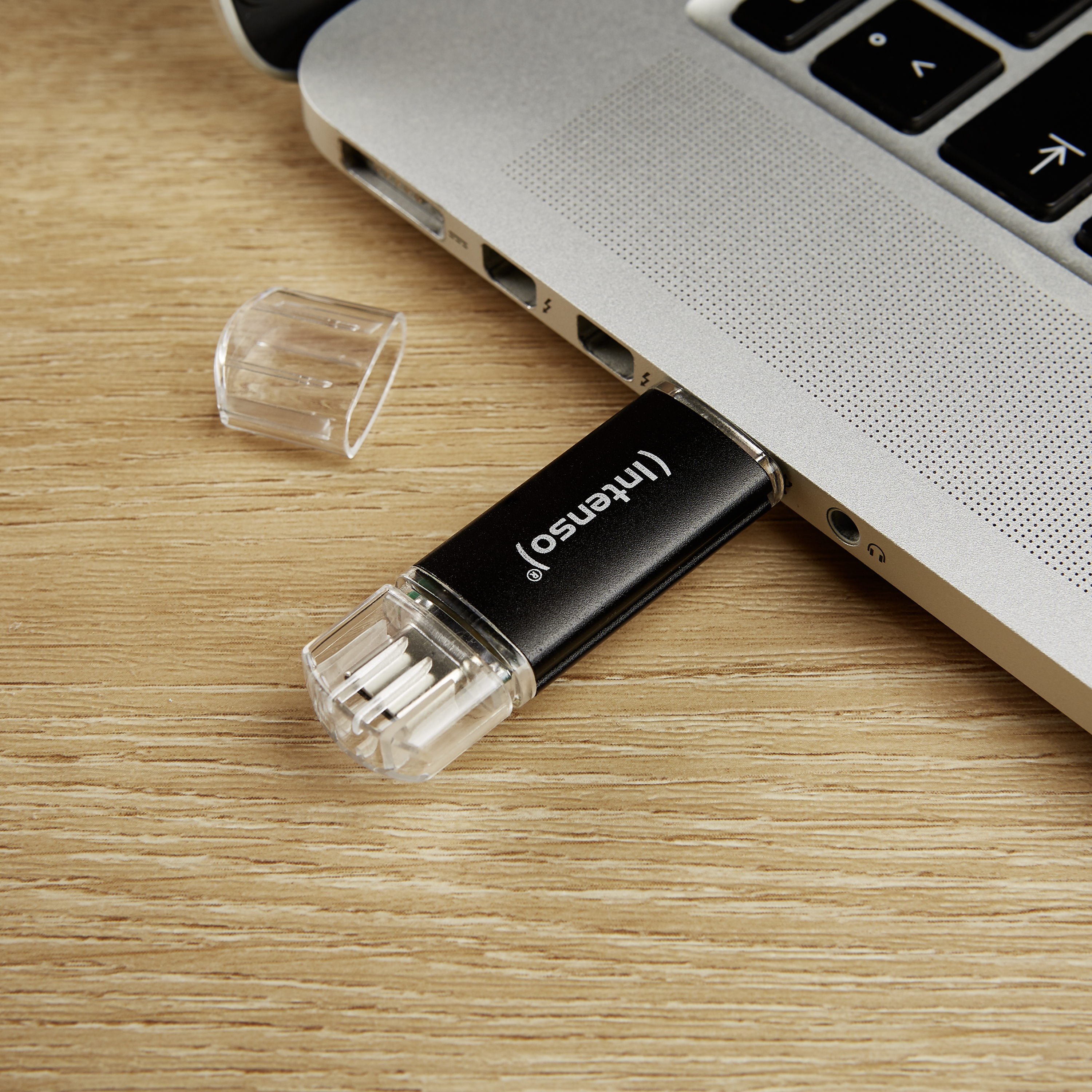 USB flash meghajtó egy laptopba helyezve. Fa háttér.