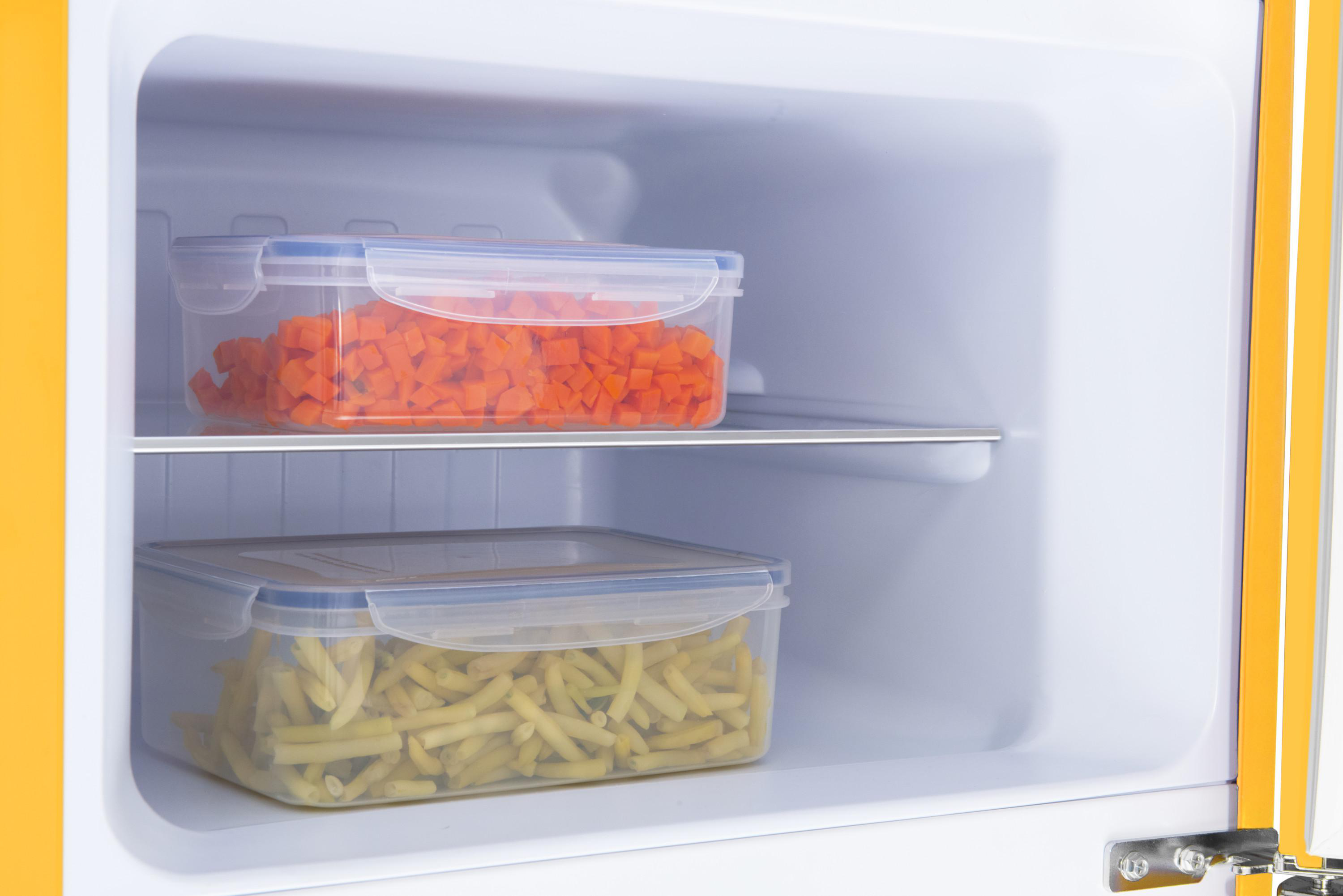 Kühlschrank-Innenraum mit zwei transparenten Behältern, Karotten und Pommes.