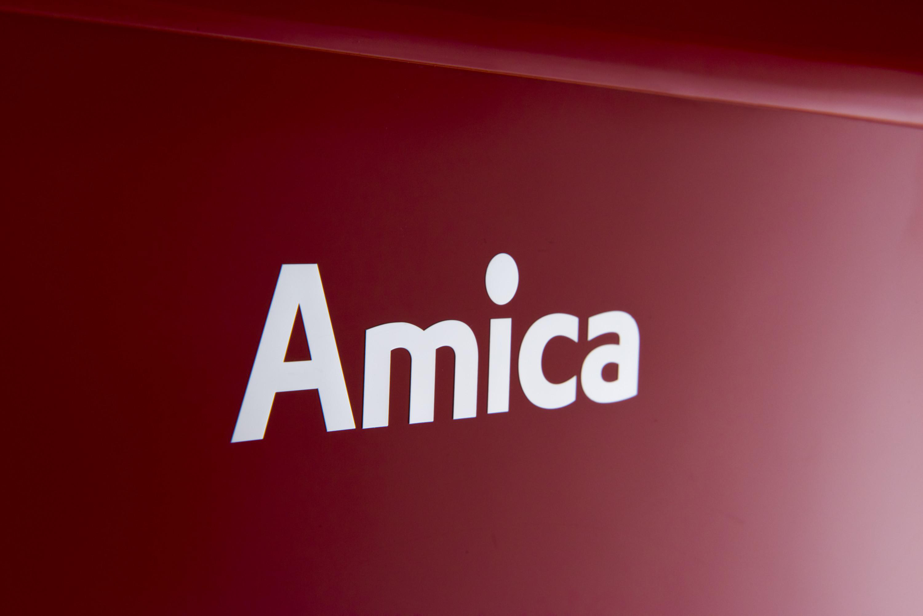 Eine Hand hält eine Bosch-Mixerflasche mit lila Smoothie. Ein Mixer ist im Hintergrund.
