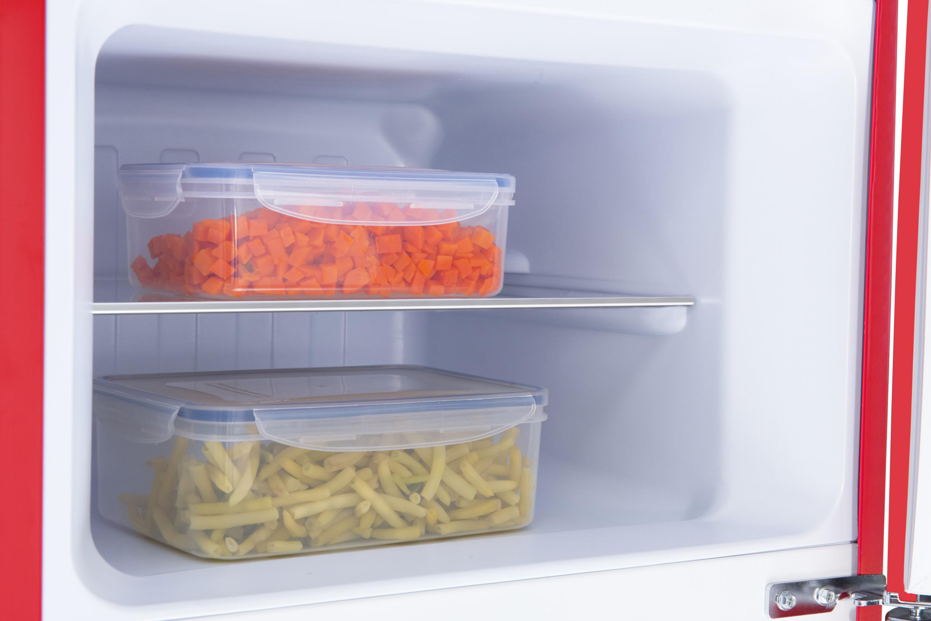 Ein K ühlschrankinnenraum mit zwei transparenten Behältern mit gehackten Karotten und Pommes.