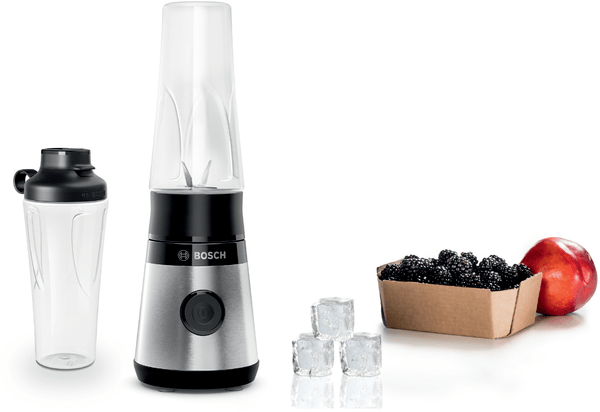 Bir blender, bir çalkalayıcı, buz küpleri, böğürtlenler ve bir şeftali beyaz bir yüzeyde düzenlenmiş.
