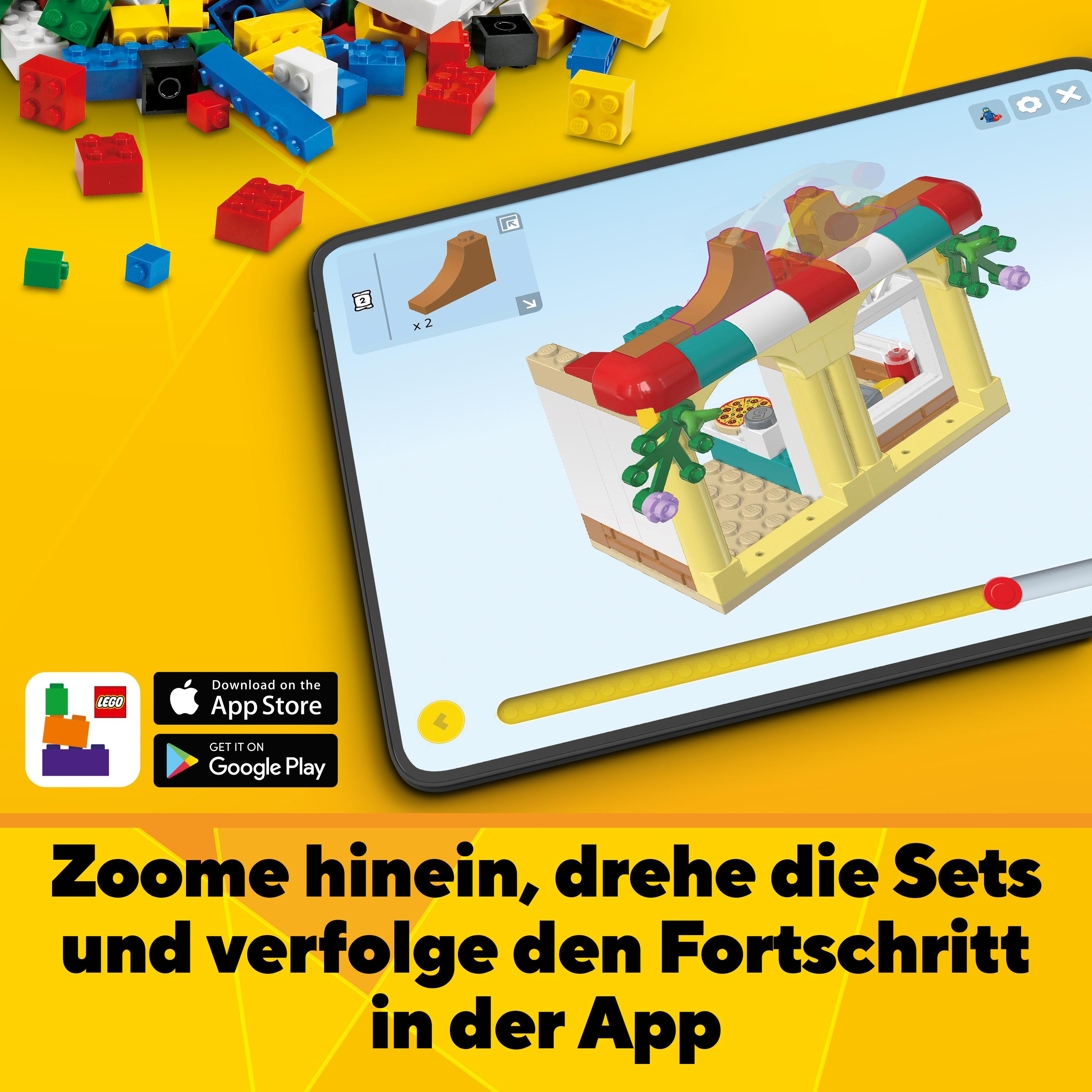 Ein Tablet mit Lego-Anweisungen auf dem Bildschirm. Ein Lego-Modell wird gebaut.
