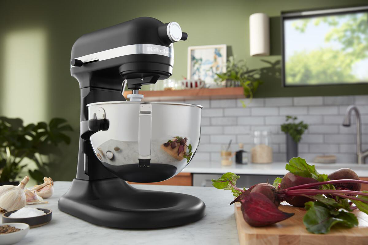 Schwarzer KitchenAid-Mixer, Edelstahlschüssel, Rüben, Knoblauch und Salz auf Marmortisch.