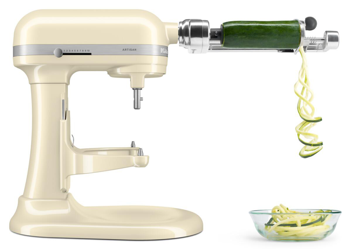 Ein KitchenAid-Küchenmixer mit einem Zucchini-Spiralschneider-Aufsatz, der eine grüne Zucchini spiralförmig schneidet.